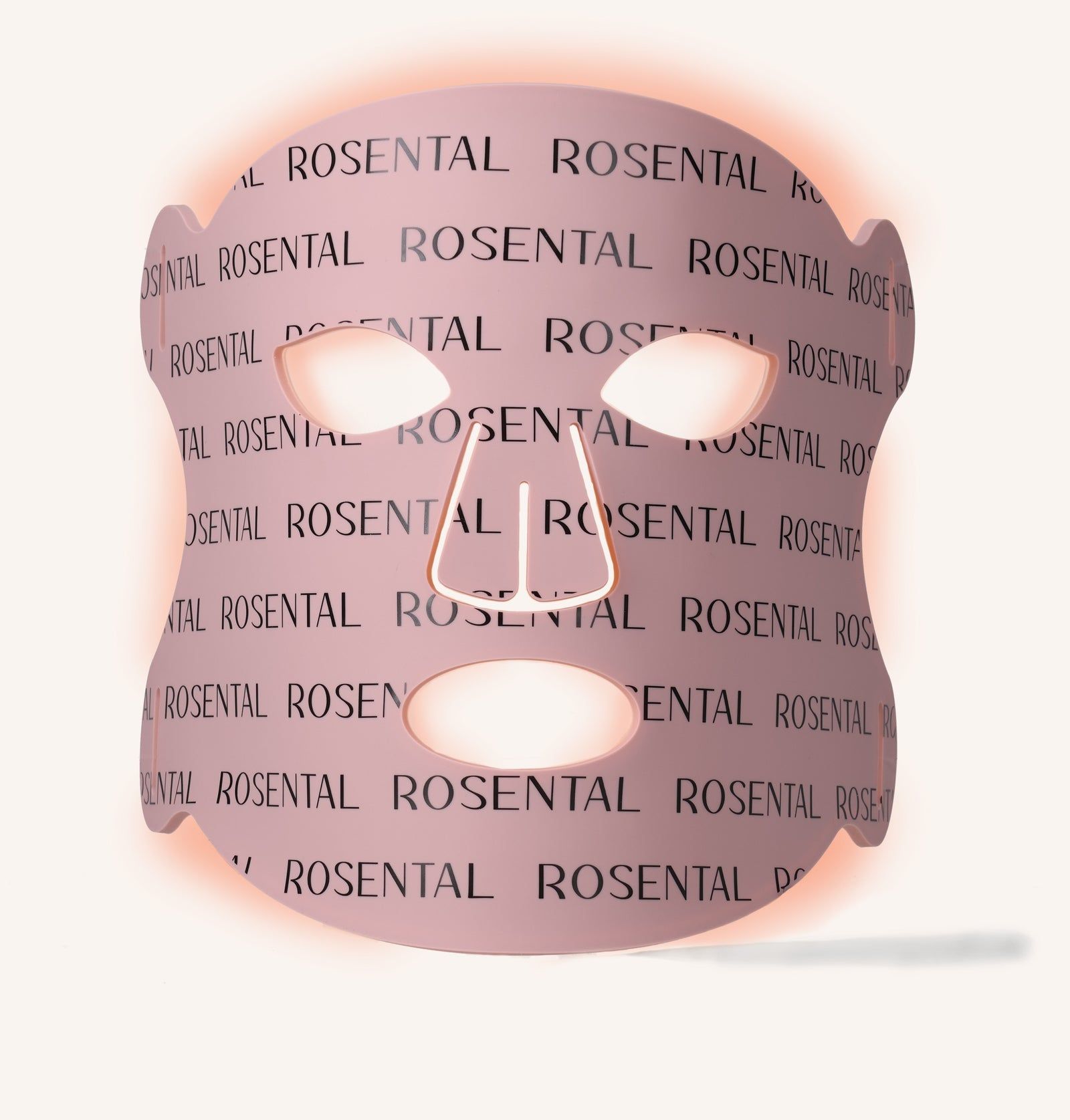 Rosa LED-Gesichtsmaske mit Aussparungen für Augen, Nase und Mund. Der Schriftzug ROSENTAL ist wiederholt aufgedruckt. Lichteffekt.