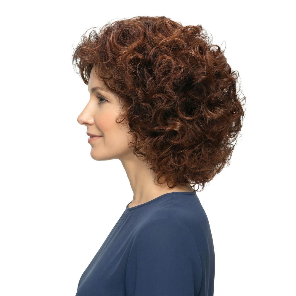 Frau mit brauner Perücke mit Locken, Seitenansicht. Sie trägt ein blaues Oberteil. Weißer Hintergrund.