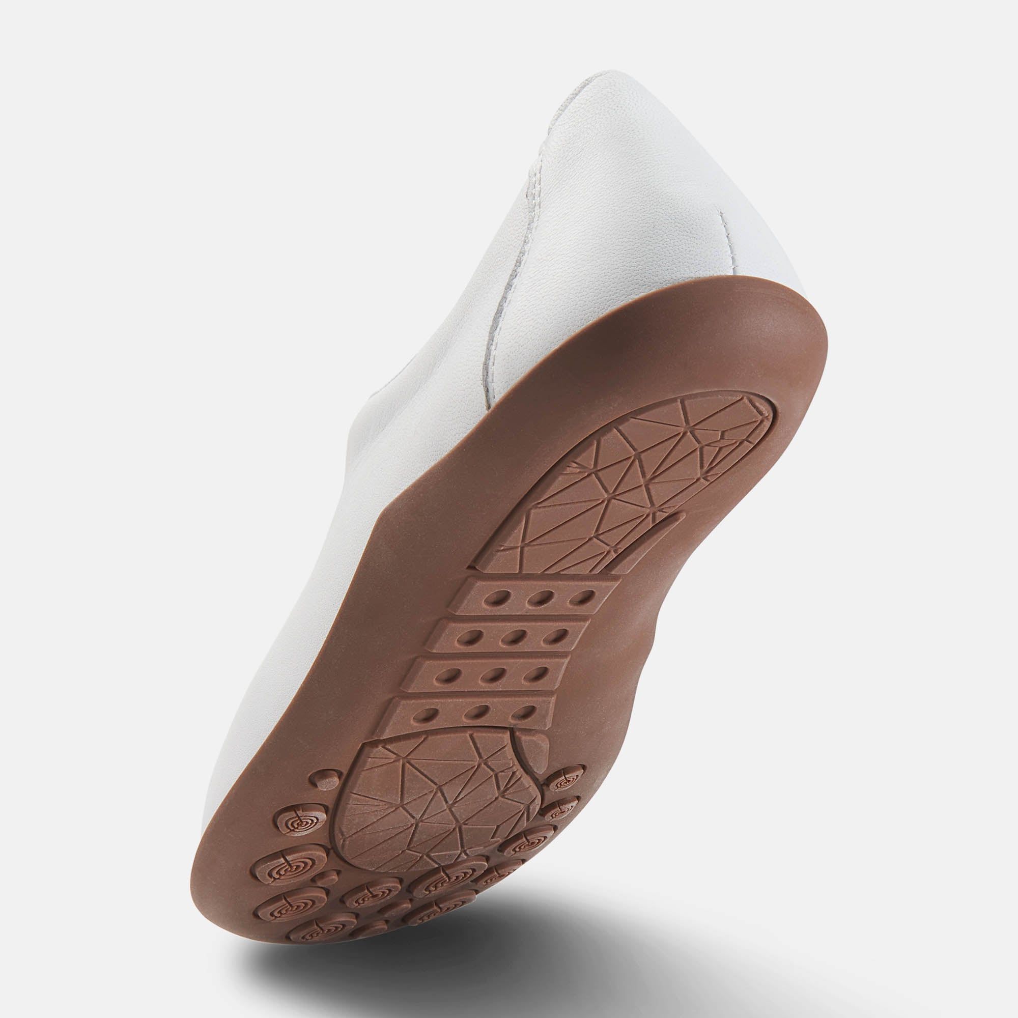 Sohlenansicht eines weißen Slippers. Braune Sohle mit geometrischem Muster und Profil.