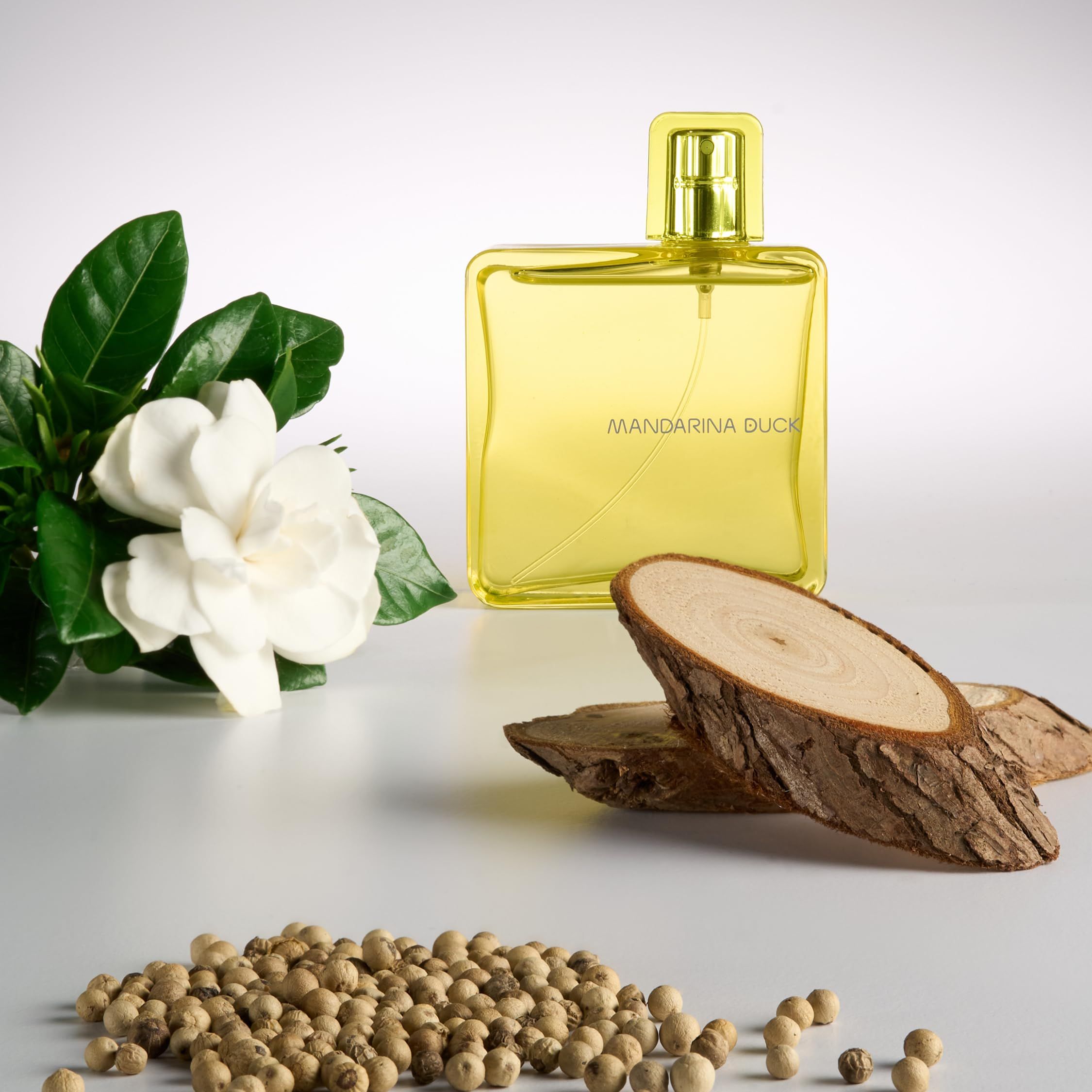 Gelbes Eau de Toilette Spray. Flasche mit Blumen und Holzstücken. Schriftzug Mandarina Duck.