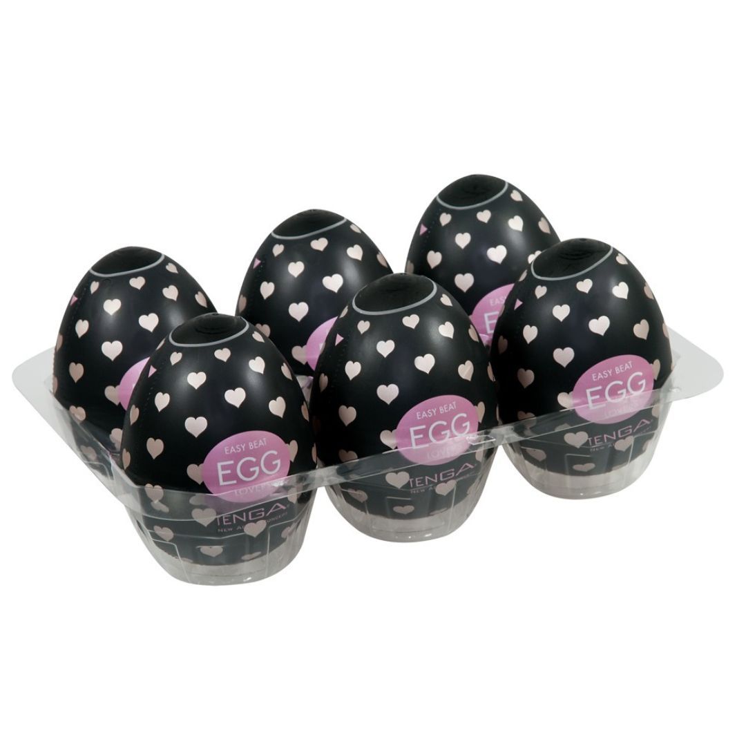 Sechs Eier in einer transparenten Verpackung. Schwarze Eier mit weißen Herzen und rosa Etikett.