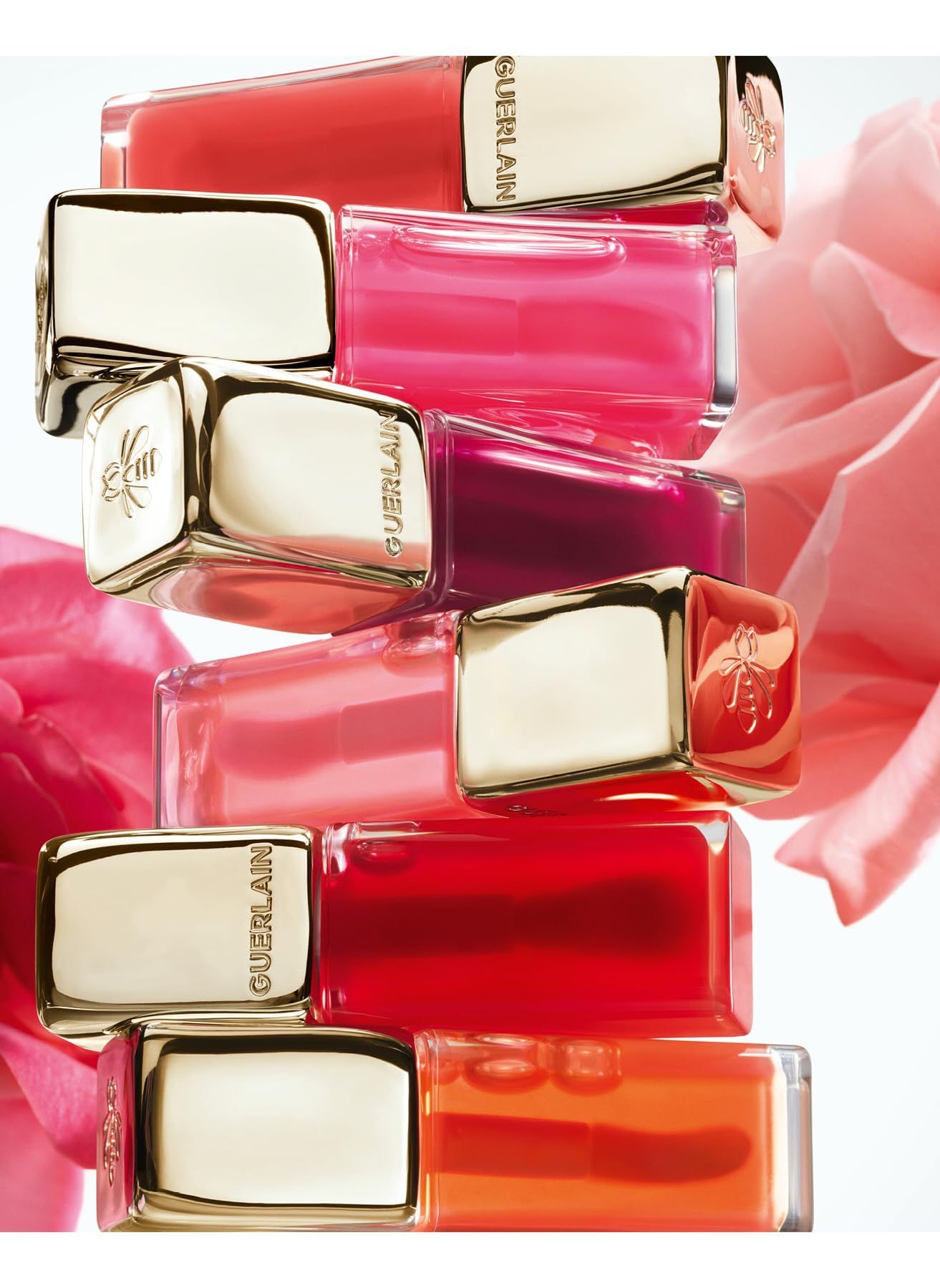 Gestapelte Lipgloss-Tuben. Goldene Kappen, "GUERLAIN" sichtbar.