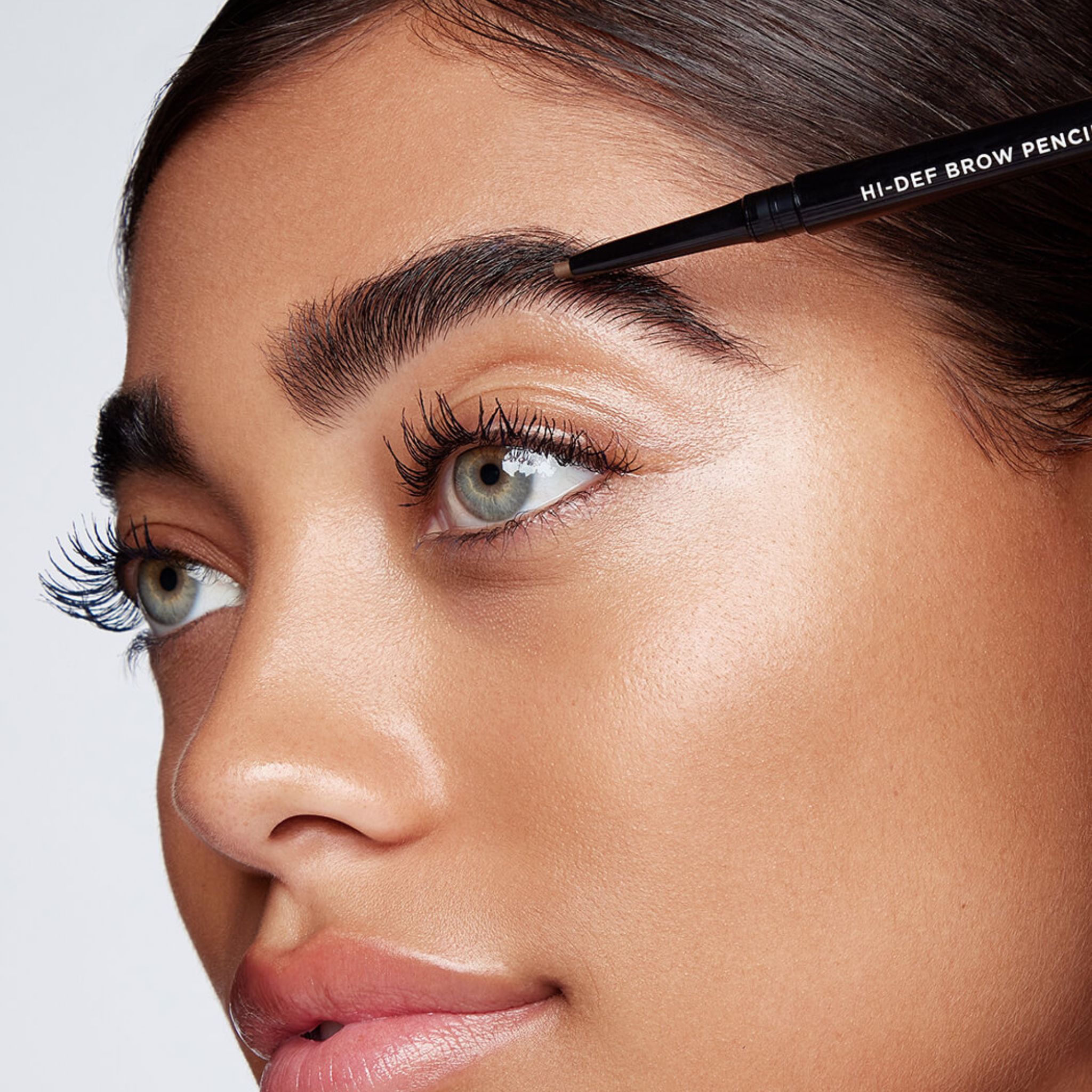 Frau mit RevitaLash Hi-Def Brow Pencil in Cool Brown, die ihre Augenbrauen nachzeichnet.