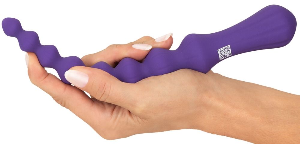 Violettfarbener Anal-Wand in einer Hand gehalten. Wellenförmige Oberfläche.