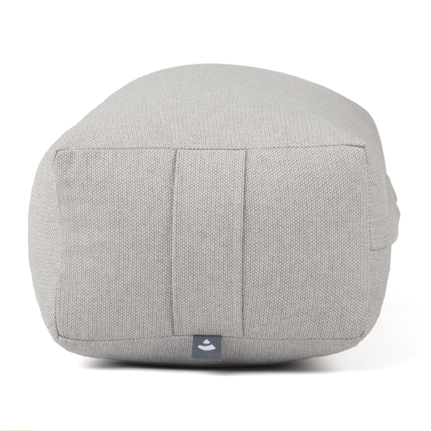Grauer Yoga-Bolster, Unterseite. Stoffstruktur sichtbar. Logo-Detail. Rechteckige Form mit Falten.