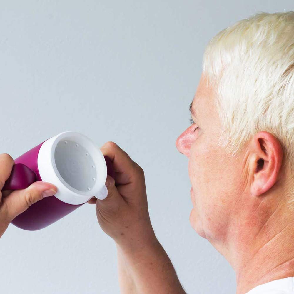 Person hält einen Becher mit Trinkaufsatz. Der Becher ist lila-weiß.