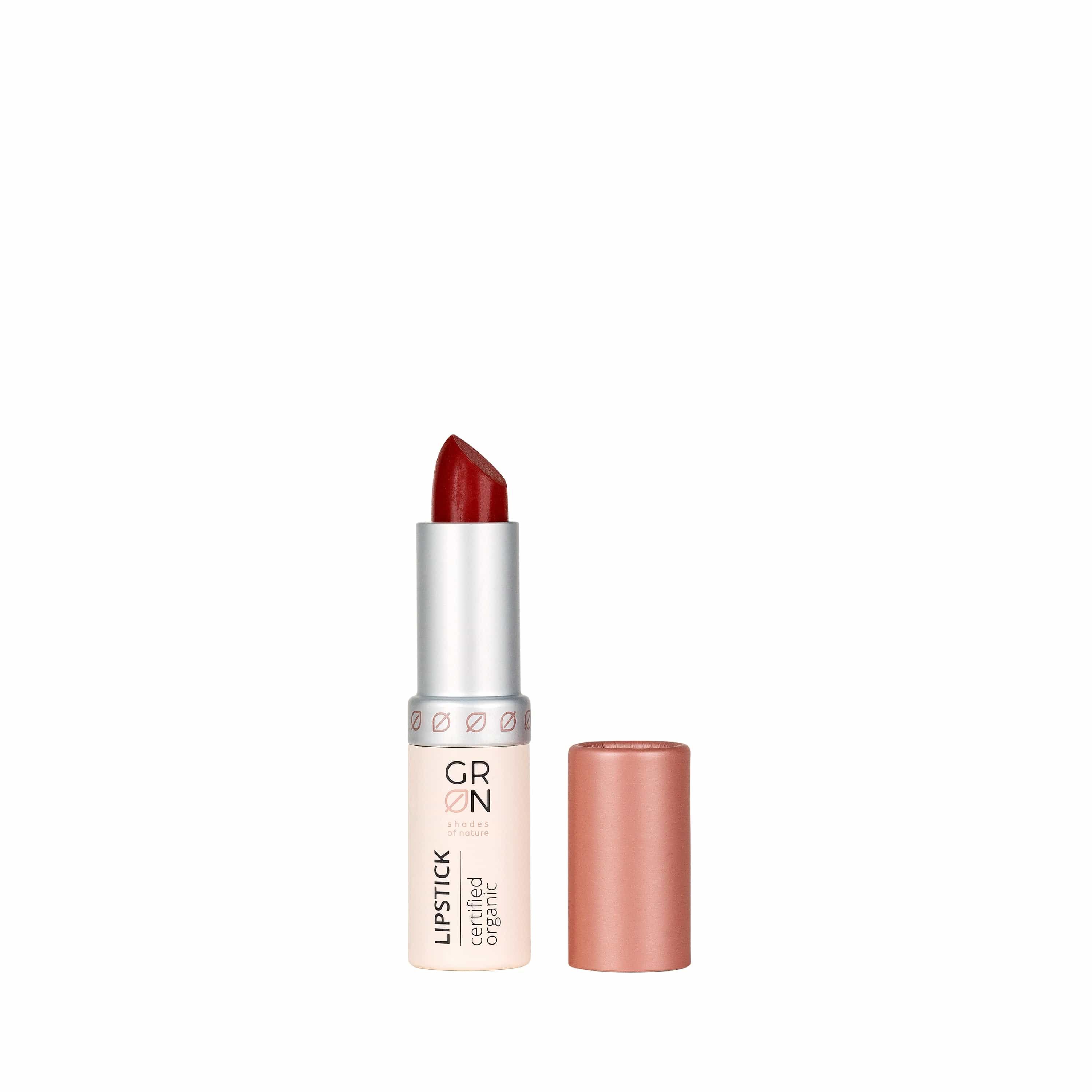 Lippenstift, geöffnet, mit roter Spitze. Silberne Hülse mit Schriftzug GRN und 'certified organic'. Rosa Kappe daneben.