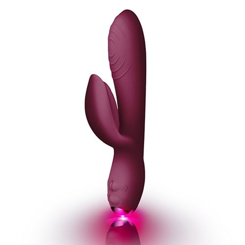 Burgunderfarbener Vibrator mit gebogener Form. Mit einem länglichen Schaft und einem gebogenen Teil. Die Spitze leuchtet rosa.