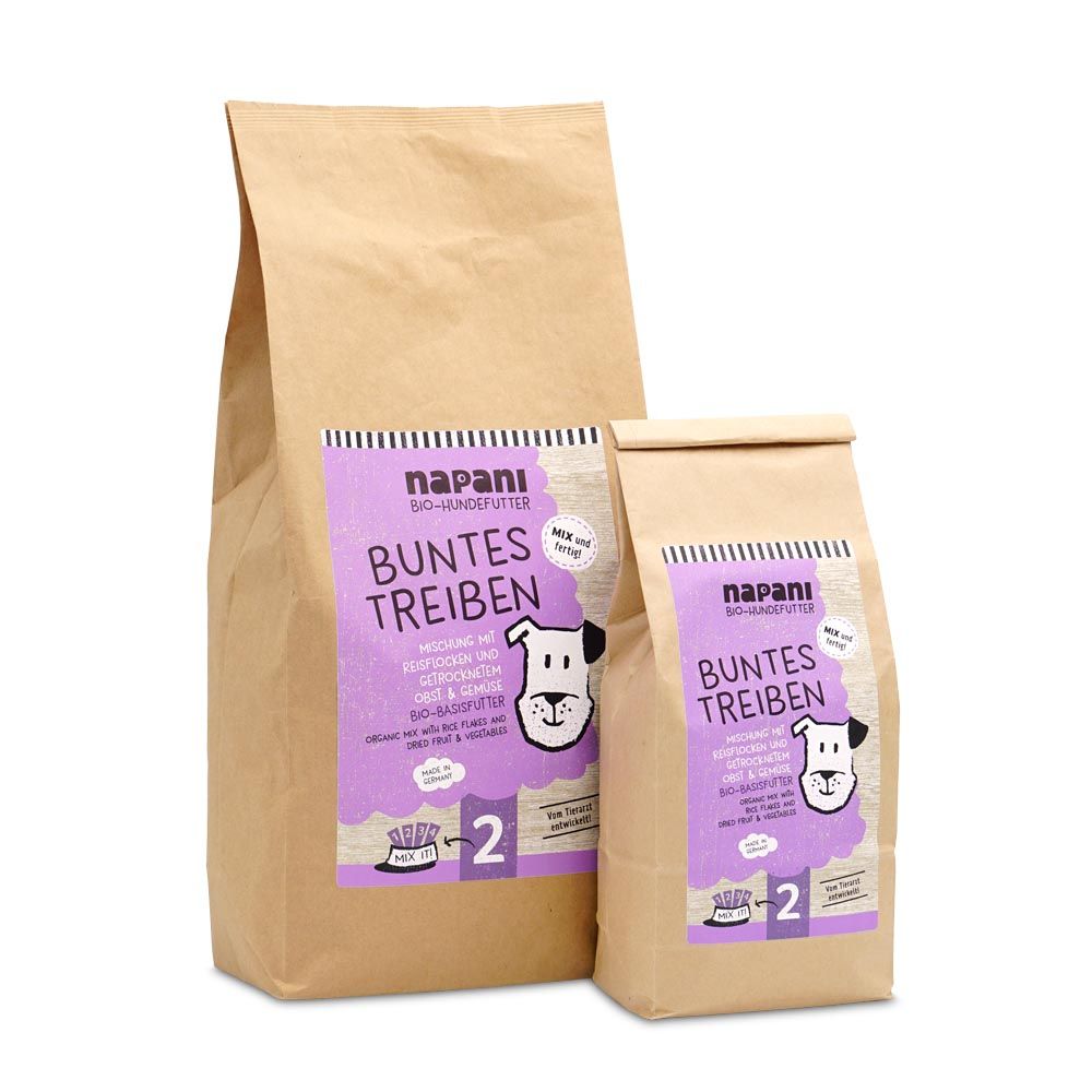 Zwei Papiertüten mit lila Etiketten. Aufschrift: napani Bio-Basisfutter "Buntes Treiben" für Hunde. Mit Hundegesicht.