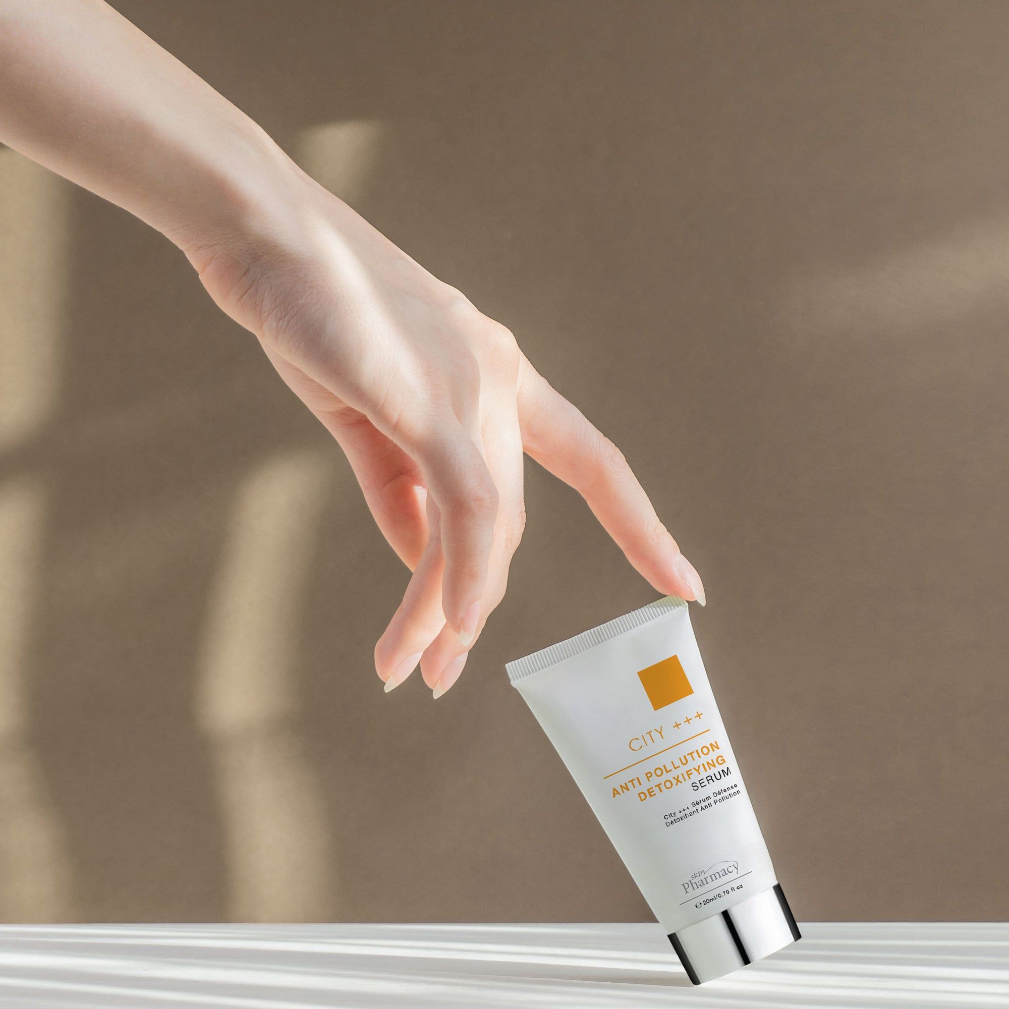 Hand berührt eine Tube. Aufschrift: CITY +++, Anti Pollution Detoxifying Serum. Marke: skinPharmacy.
