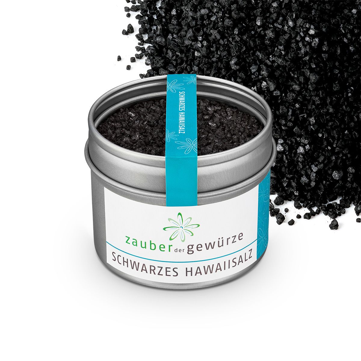 Geöffnete Dose mit schwarzem Hawaii-Meersalz. Aufschrift: Zauber der Gewürze, Schwarzes Hawaii-Salz. Türkisband. Schwarzes Salz daneben.