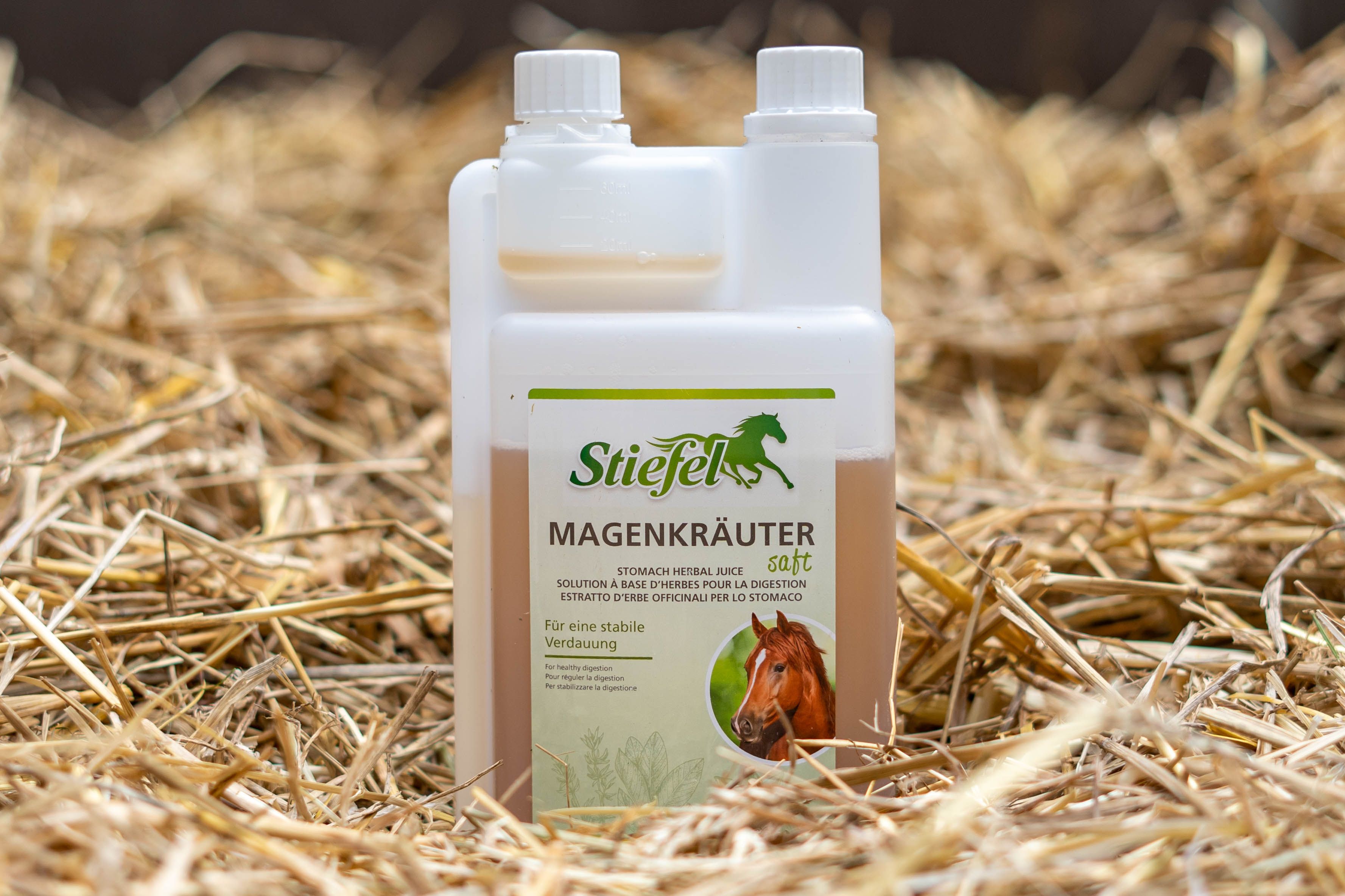 Flasche Kräutersaft auf Stroh. Label mit Produktnamen und Logo. Flasche mit zwei Kammern.