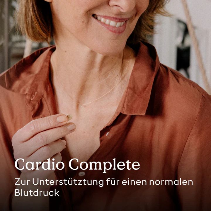 Frau hält Kapsel. Text: "Cardio Complete". Zur Unterstützung für einen normalen Blutdruck.