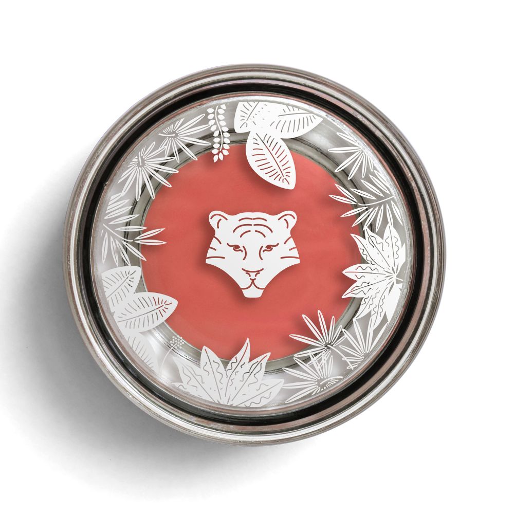 Runder Behälter mit rosafarbenem Inhalt. Deckel mit Tigerkopf-Motiv und Blättern. Metallrand.