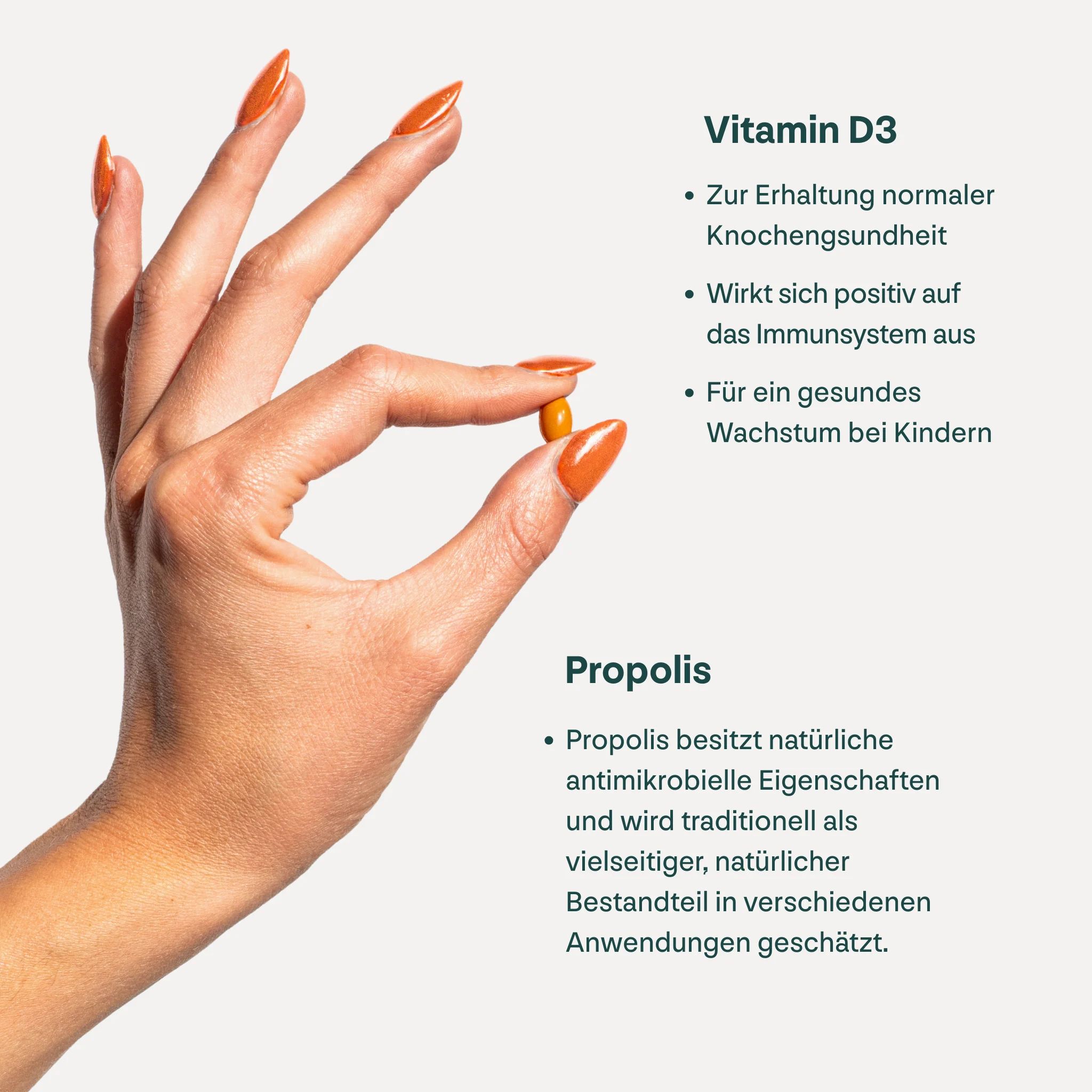 Hand hält eine gelbe Kapsel. Text: Vitamin D3. Propolis. Zur Erhaltung normaler Knochengesundheit. Wirkt sich positiv auf das Immunsystem aus.
