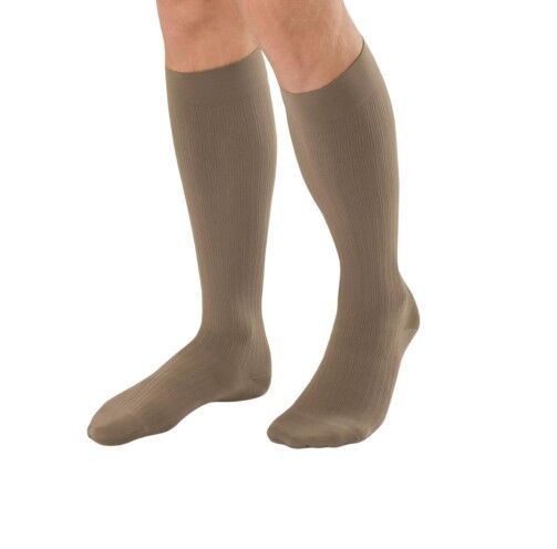 Beige Kompressions-Kniestrümpfe. Geripptes Material. Die Strümpfe bedecken den Fuß und das Bein bis zum Knie.