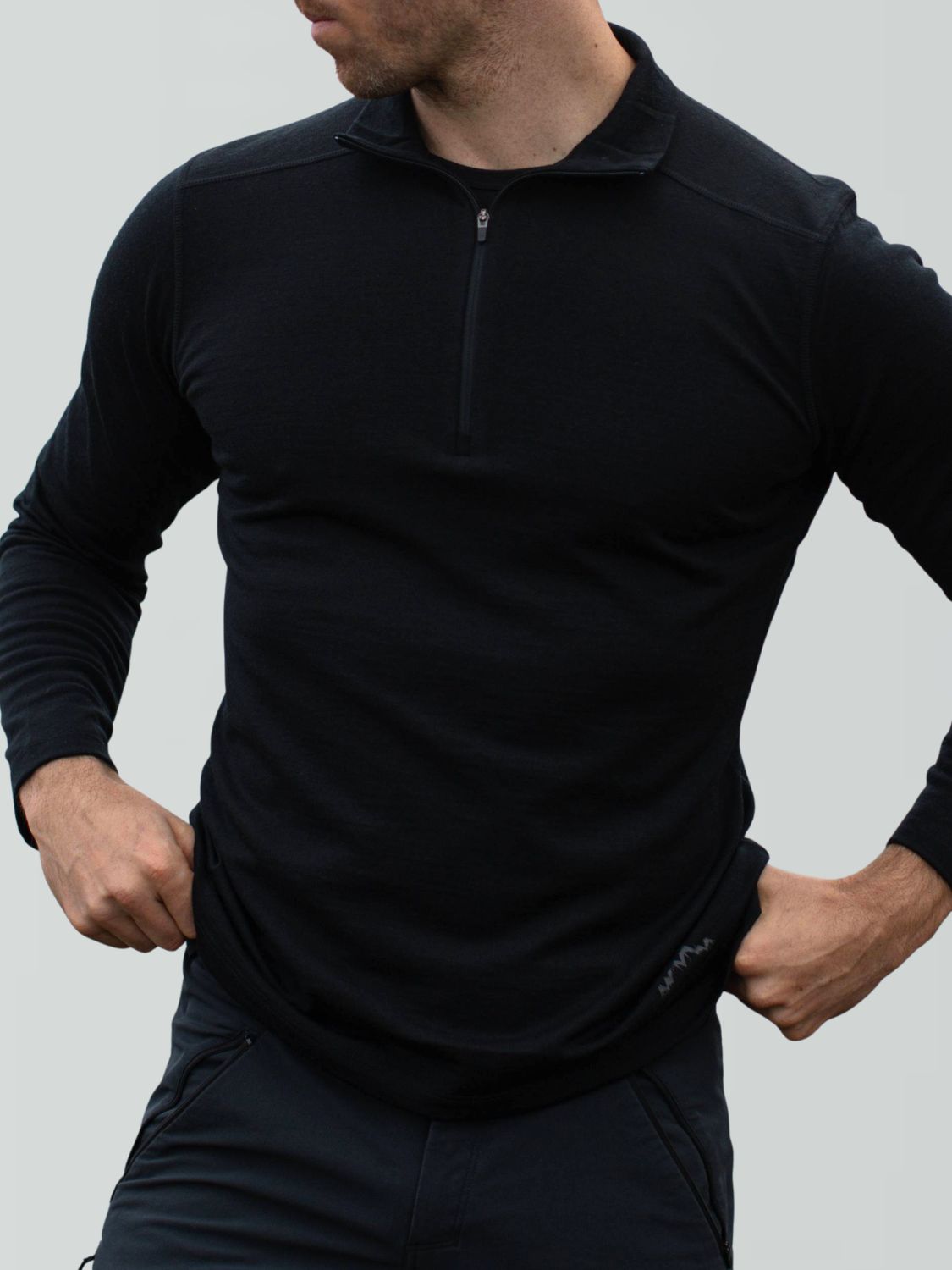 Schwarzer Herren-Merino-Pullover mit kurzem Reißverschluss am Kragen und dezentem Logo.