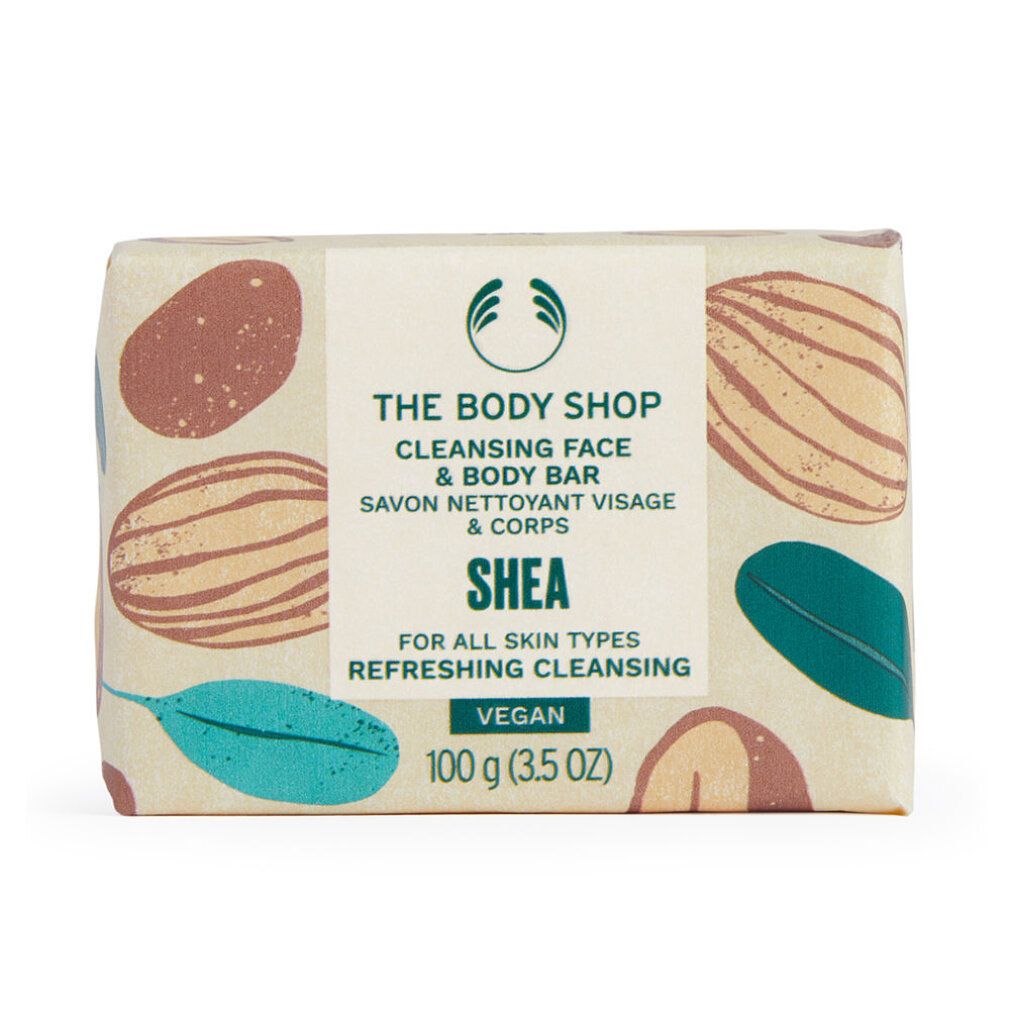 Verpackte Seife. Aufschrift: The Body Shop, Cleansing Face & Body Bar, Shea, Vegan. 100 g.