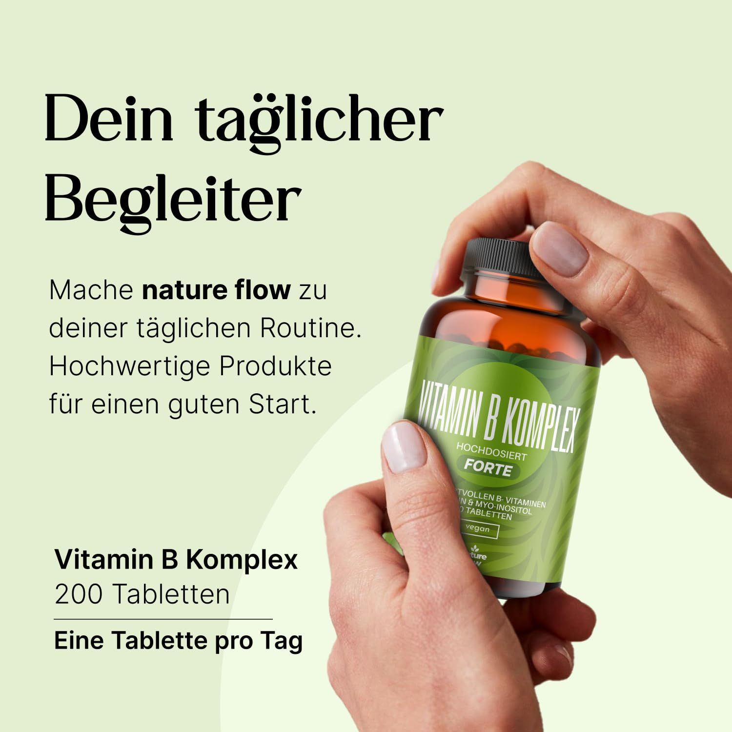 Braune Glasflasche mit grünem Etikett. Aufschrift: Vitamin B Komplex Forte, 200 Tabletten. Hand hält Flasche.