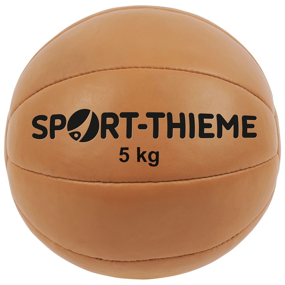 Beigefarbener Medizinball. Aufschrift: SPORT-THIEME, 5 kg. Lederoptik mit Nähten.