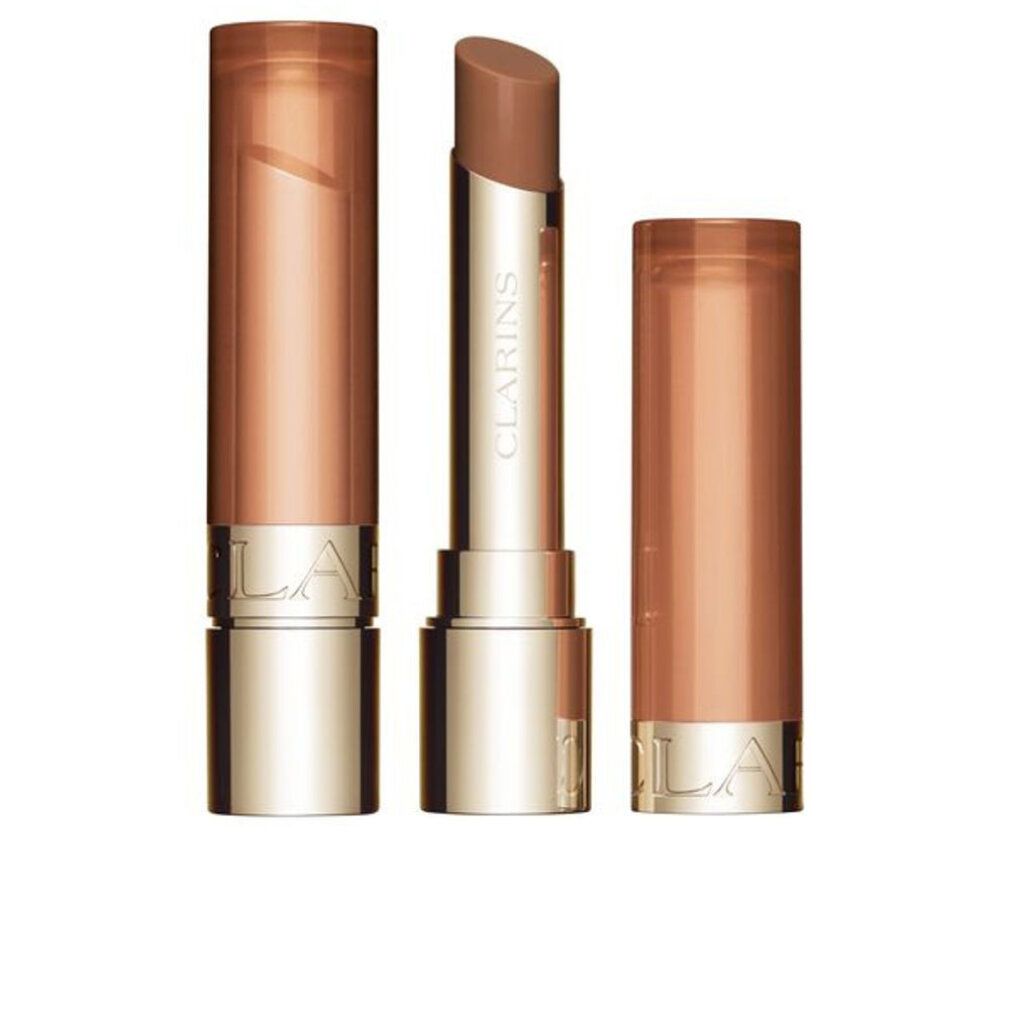 Lippenbalsam mit geöffneter Hülse. Goldfarbene Hülse mit braunem Balsam. Daneben die Hülse.