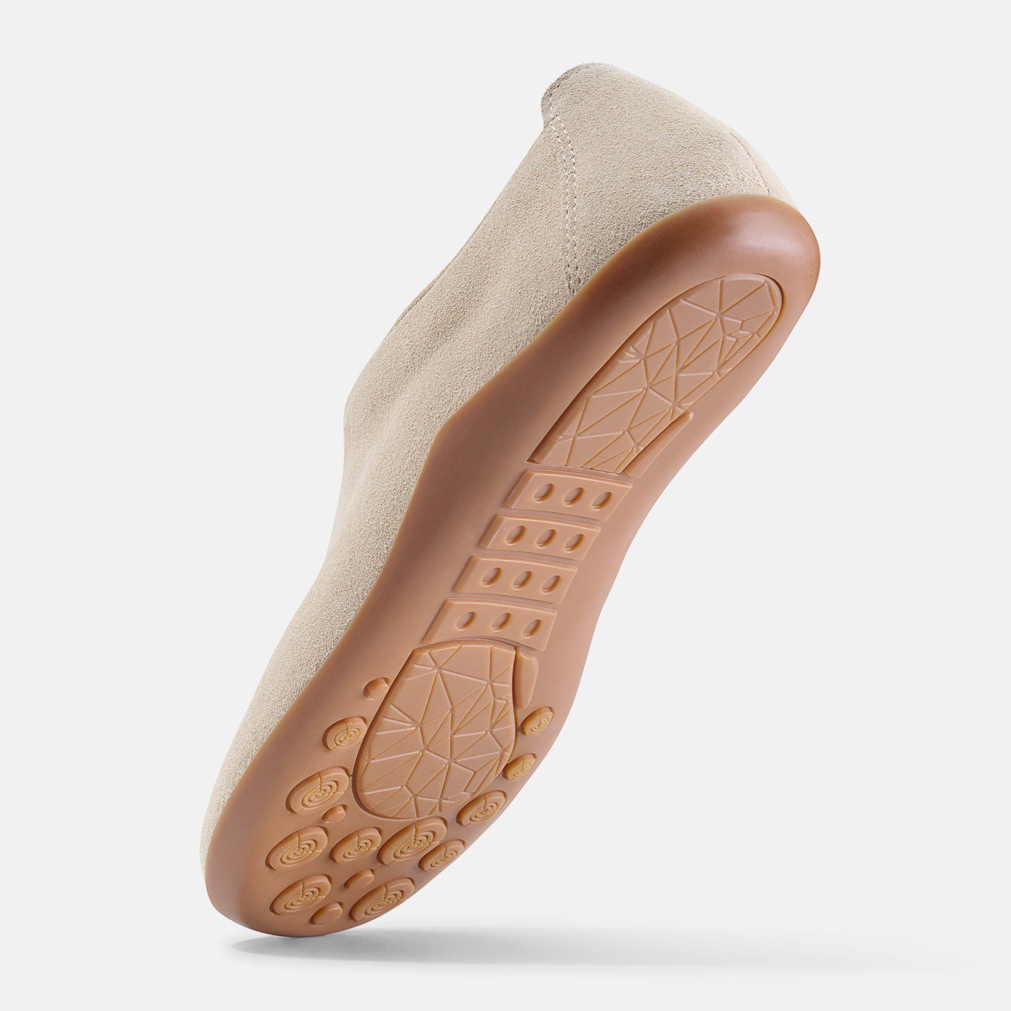 Sohlenansicht eines beigefarbenen Slippers. Braune Sohle mit Muster.