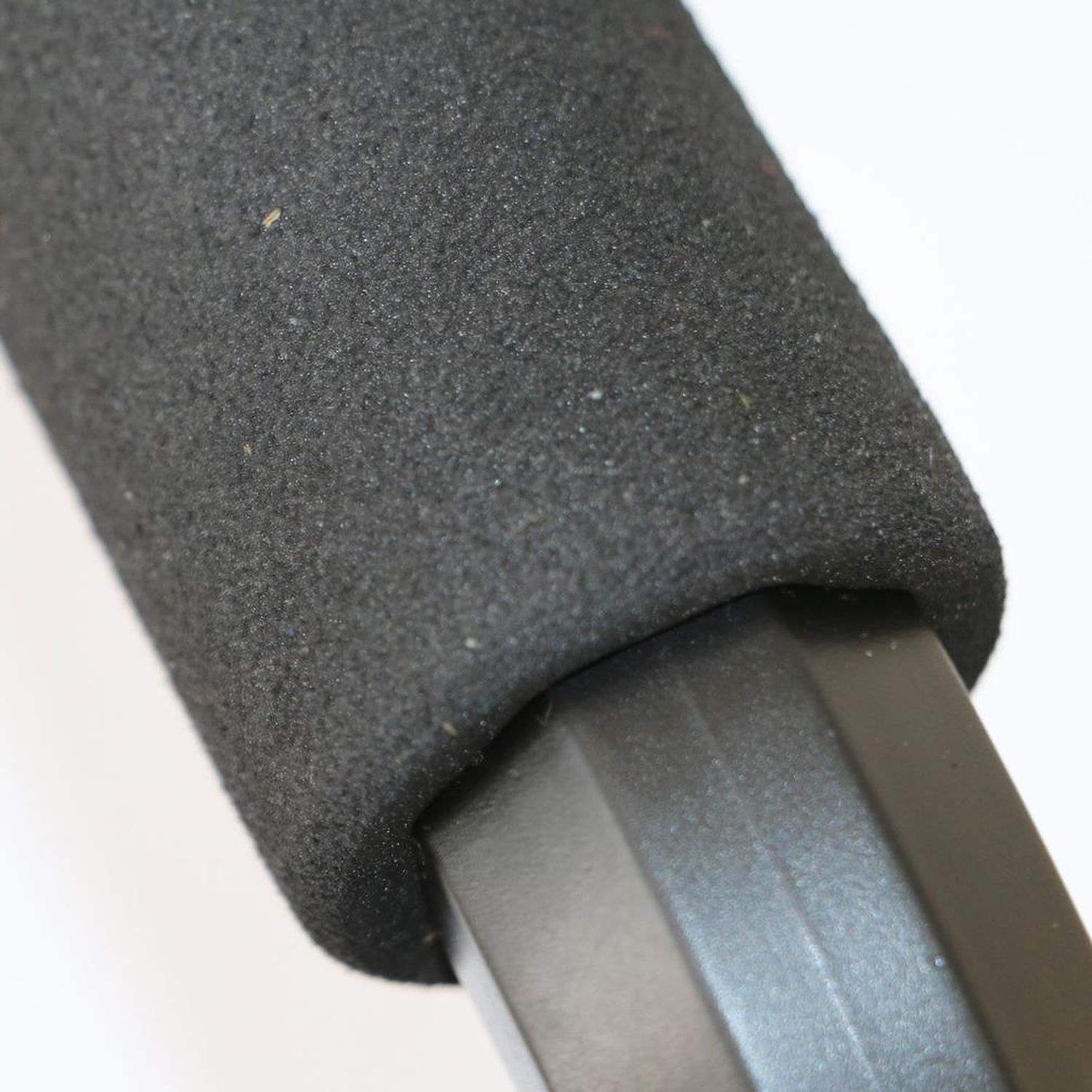 Nahaufnahme des gepolsterten Griffs einer schwarzen Push-up-Bar. Der Griff ist mit schwarzem Schaumstoff bedeckt.