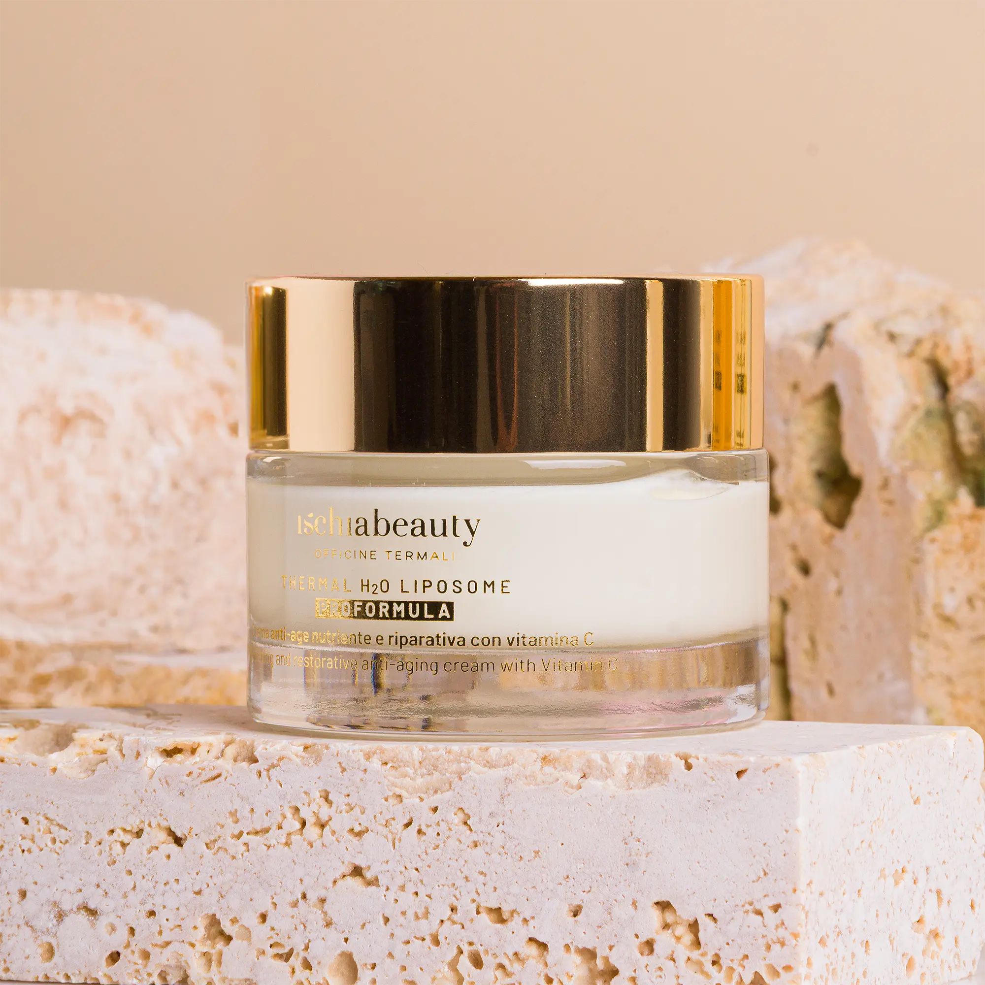 Cremebehälter mit goldenem Deckel. Aufschrift: ischiabeauty. Auf Steinblöcken platziert.