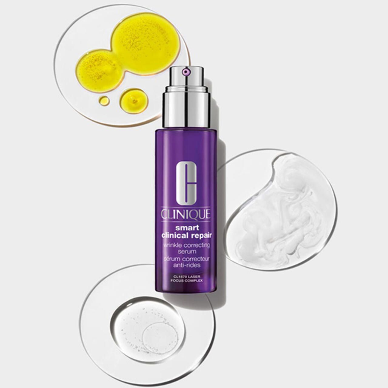 Lila Flasche mit silbernem Pumpkopf, umgeben von transparenten Kreisen mit Flüssigkeiten. Produktname: Smart Clinical Repair Serum.