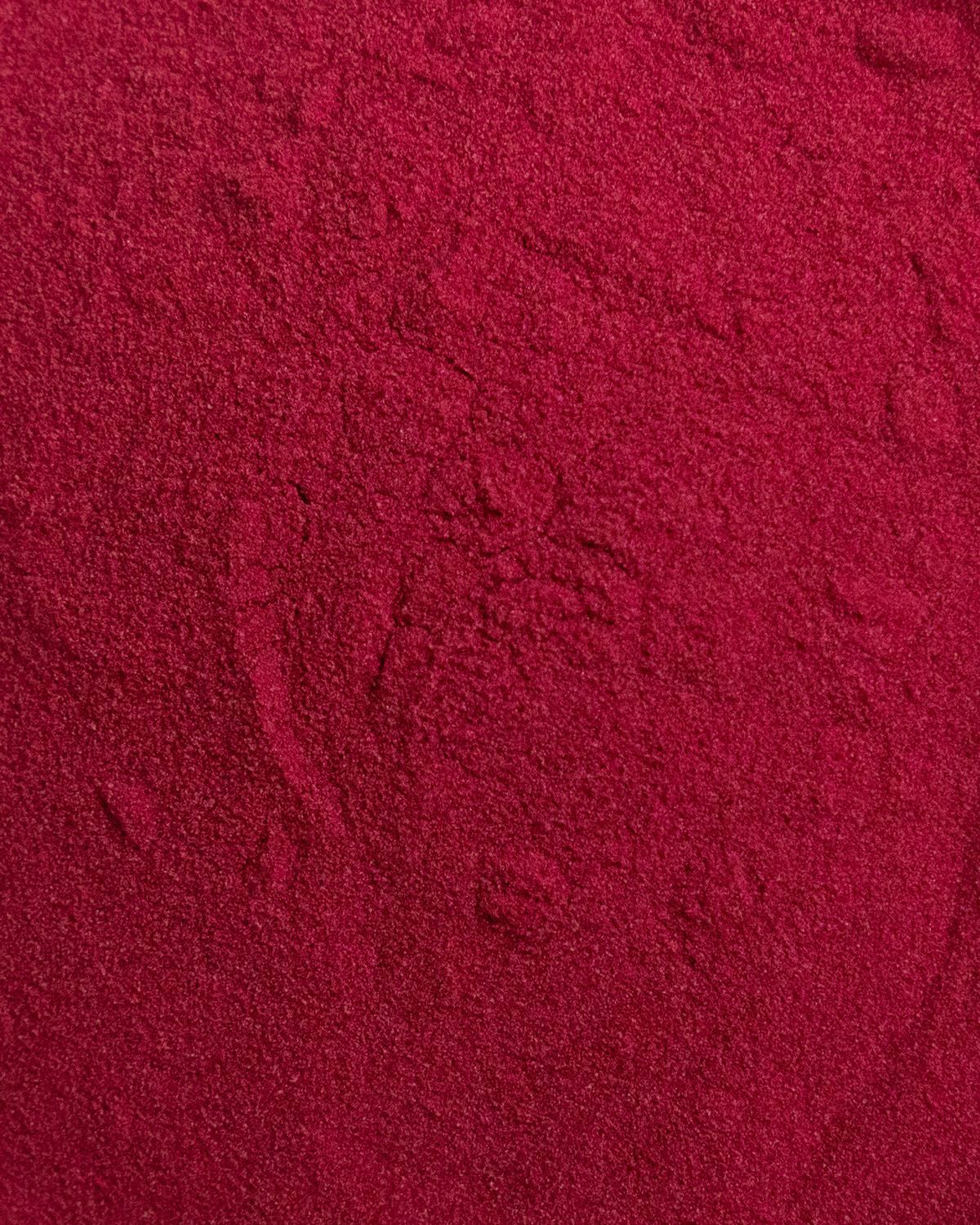 Nahaufnahme von rotem Pulver. Die Textur ist fein und leicht körnig.