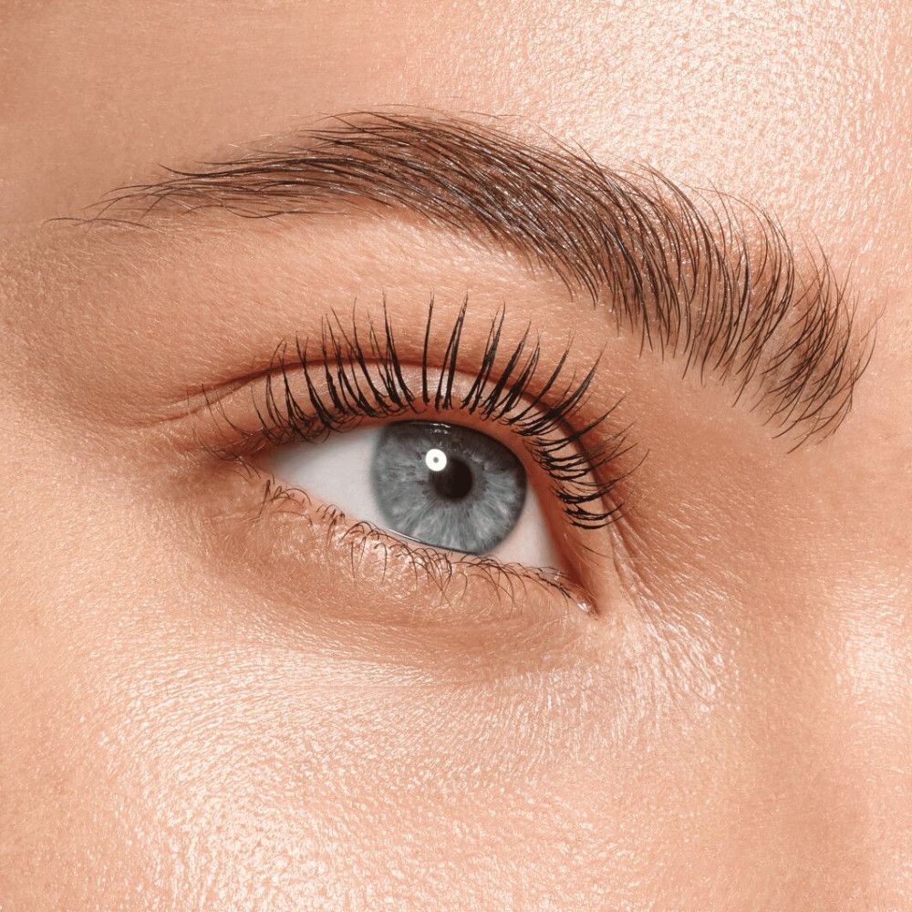 Nahaufnahme eines Auges mit getuschten Wimpern. Die Wimpern sind lang und definiert.