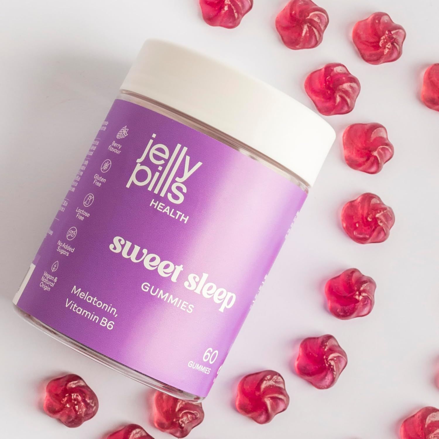 Jelly Pills Sweet Sleep Gummies. Lila Dose mit 60 Gummies. Rote Gummibärchen liegen verstreut. Enthält Melatonin und Vitamin B6.