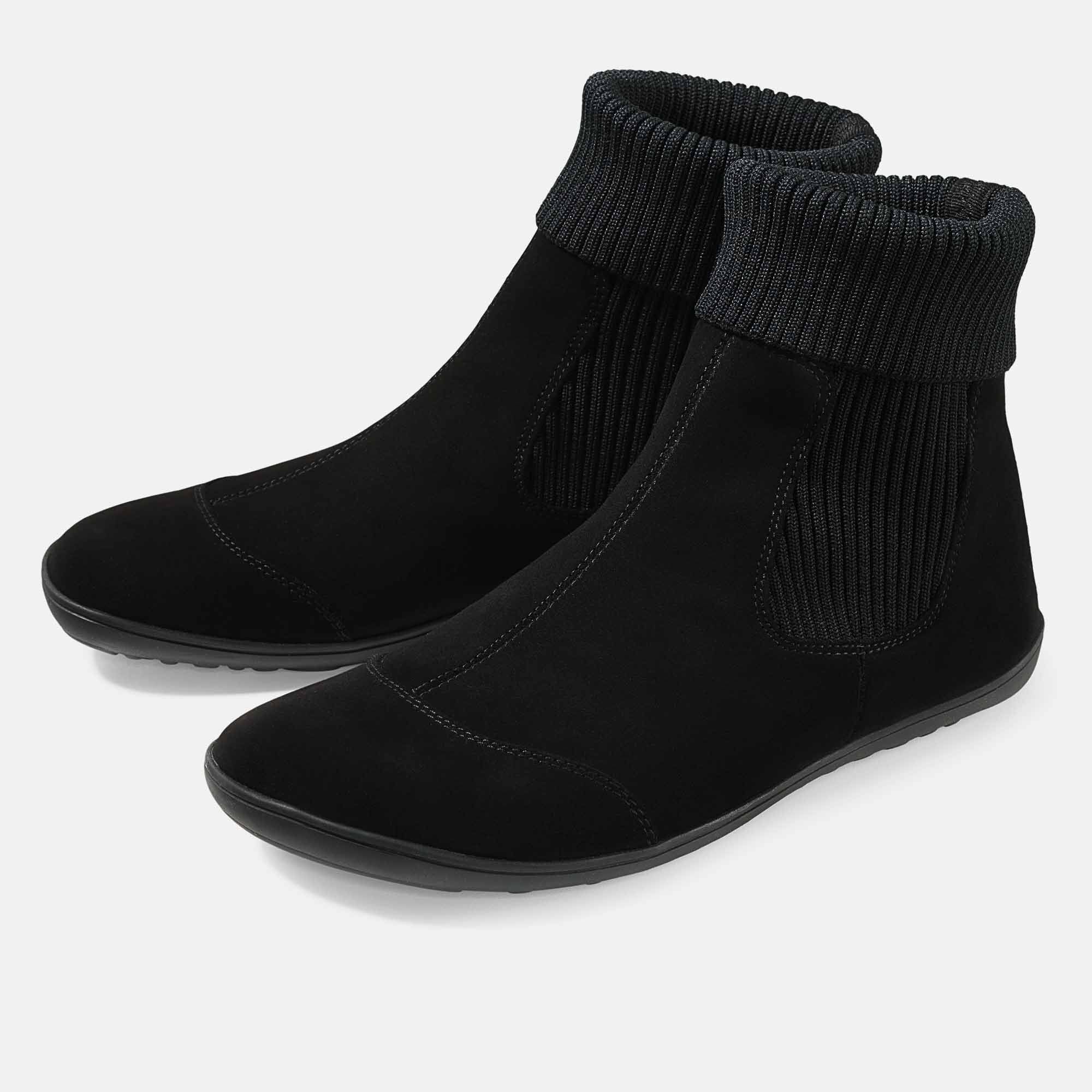 Schwarze Stiefeletten mit breiter Passform. Obermaterial aus Wildleder, Schaft aus Rippstrick. Flache Sohle.