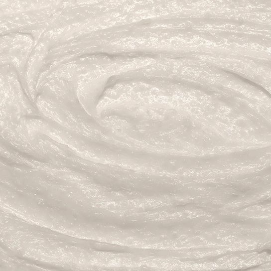 Nahaufnahme von weißer Creme. Textur mit sichtbaren Partikeln. Keine Verpackung oder Kontext.