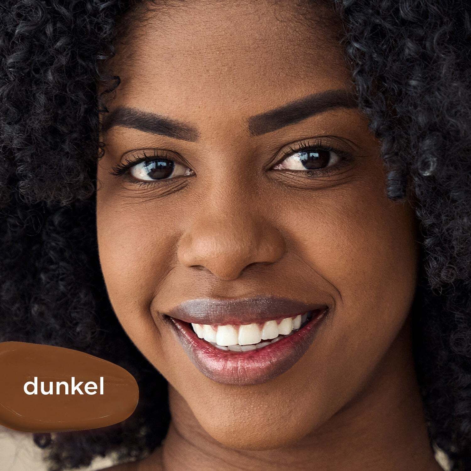 Porträt einer Frau mit dunkler Haut. Daneben ein Farbklecks in dunklem Braun mit der Aufschrift "dunkel".