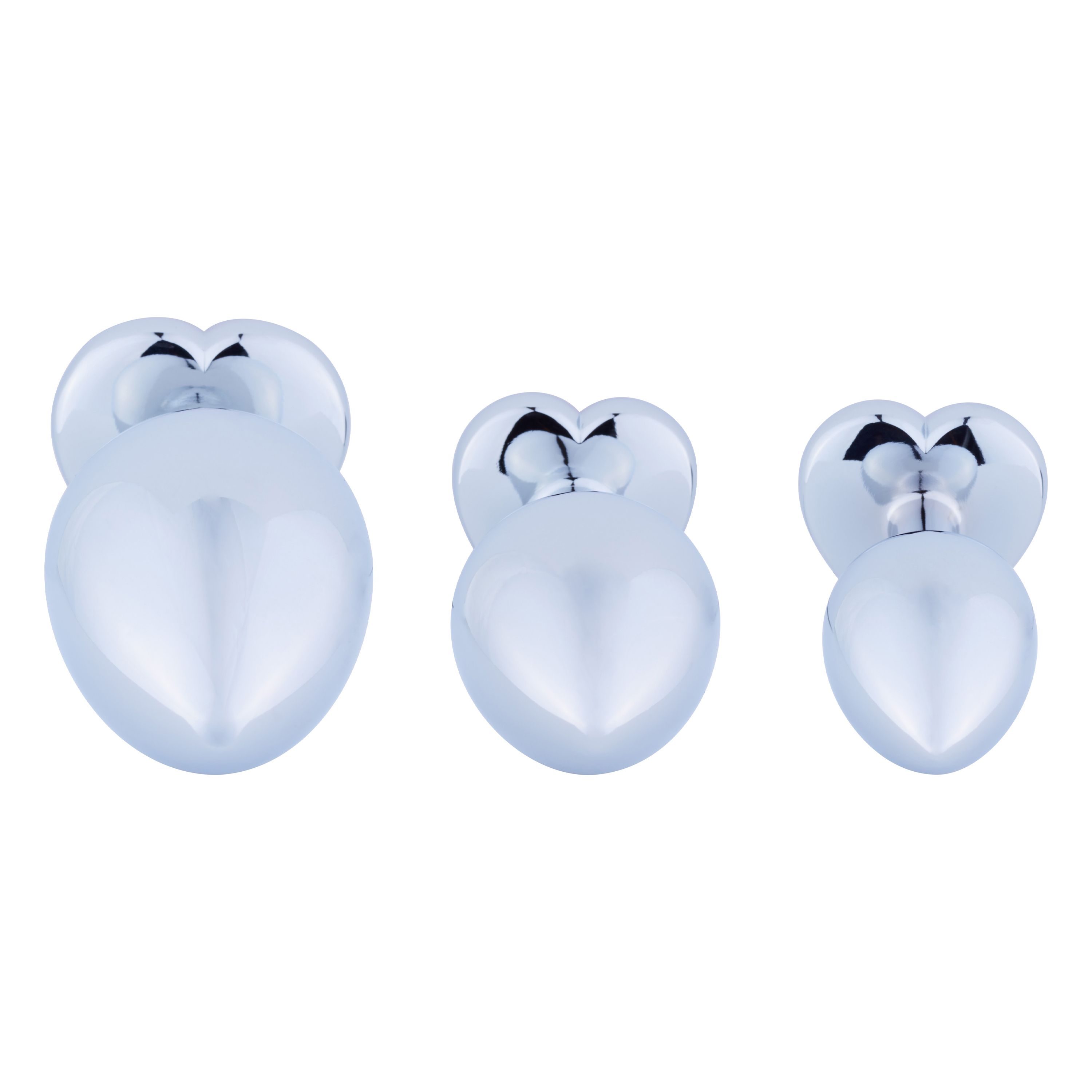 Drei metallische Analplugs in Herzform. Unterschiedliche Größen, glänzende Oberfläche.