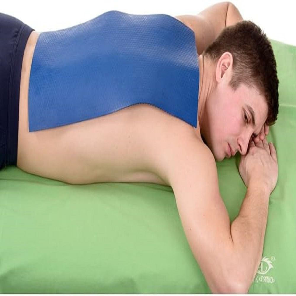 Mann liegt auf dem Bauch, blauer Akupressurmatte auf dem Rücken.