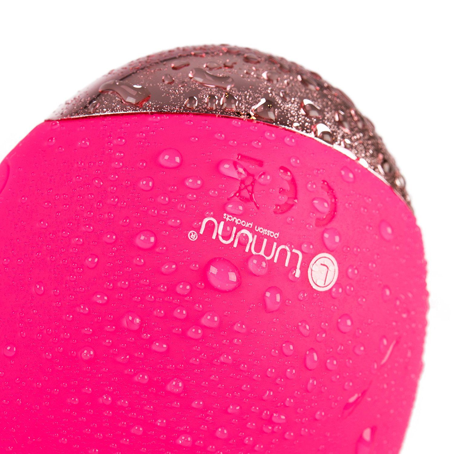 Nahaufnahme eines rosa Stimulators mit Wassertropfen. Logo 'Lumunu' und 'L' sichtbar. Silberne Unterseite.