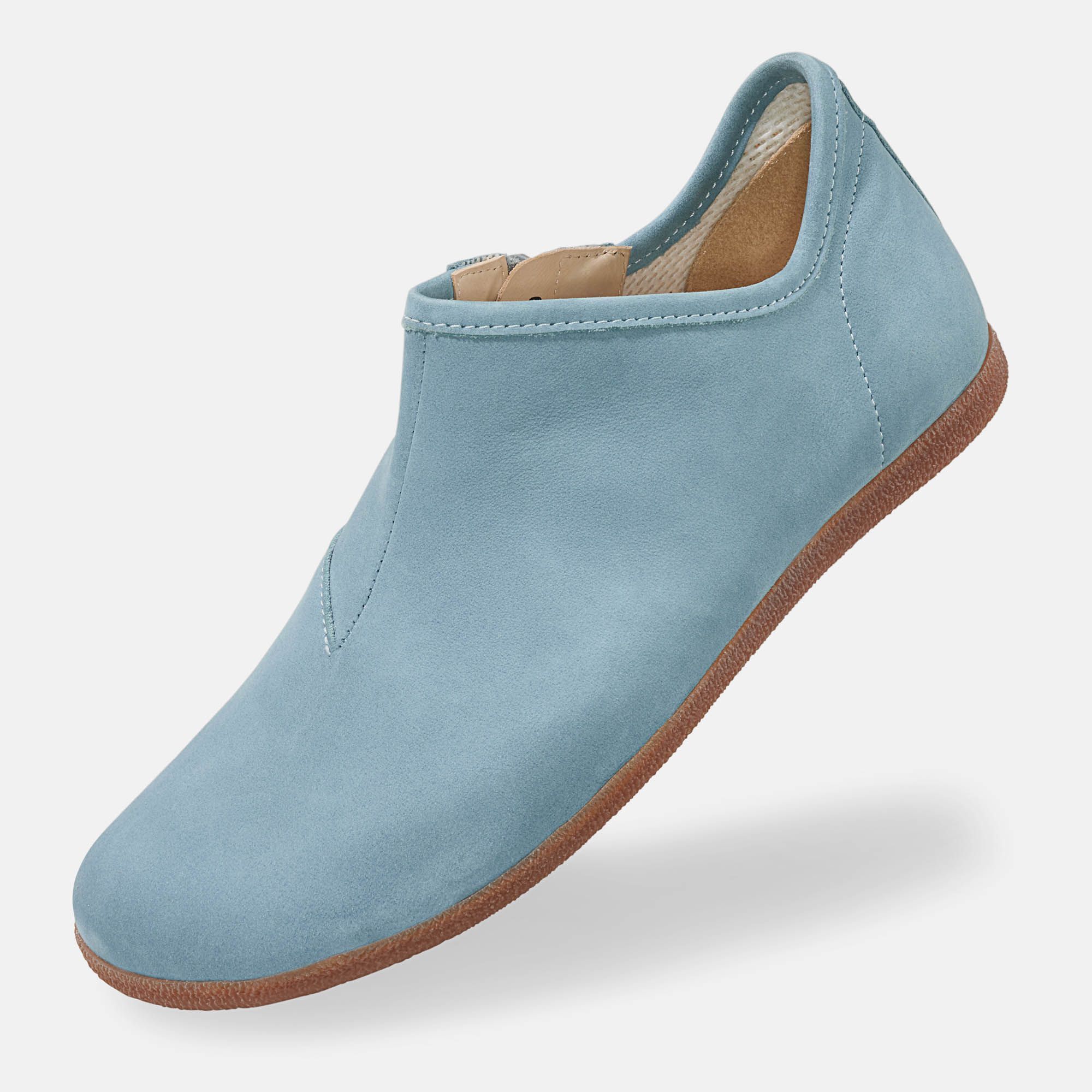Hellblauer Slipper mit brauner Sohle. Seitlicher Reißverschluss. Weite Form. Innenfutter. Einzelner Schuh, schräg gestellt.