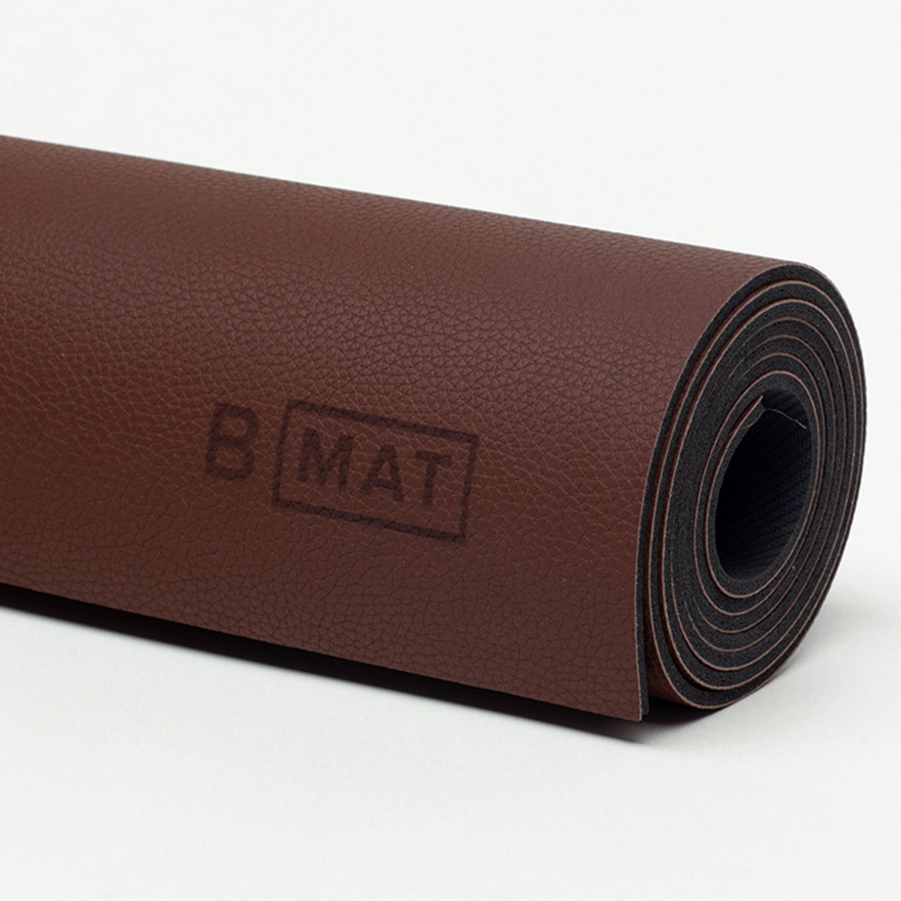 Gerollte Yogamatte, braun, mit Logo "B MAT".
