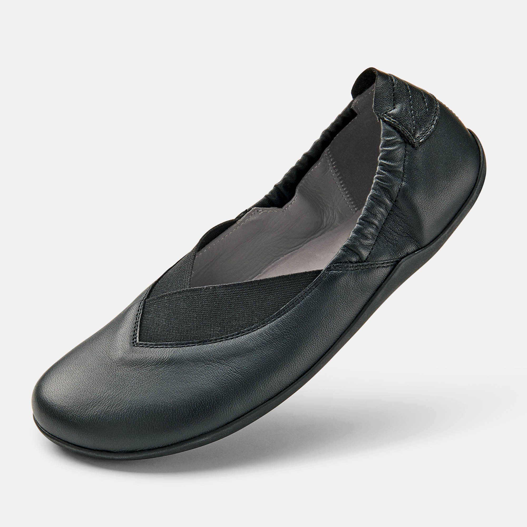 Schwarze Ballerina. Leder, elastischer Einsatz. Weite Form. Einzelner Schuh, leicht schräg gestellt.