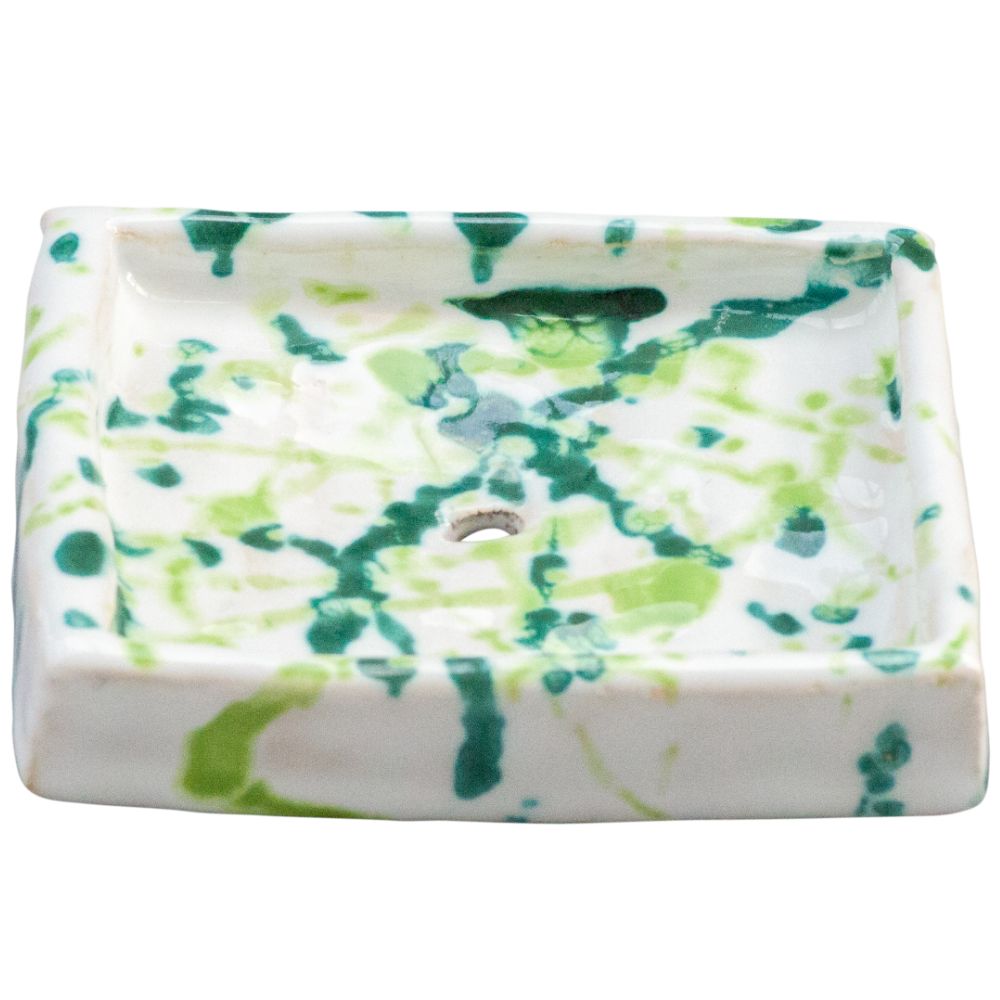 Rechteckige Seifenschale aus Keramik. Weiß mit grünen und hellgrünen Farbspritzern. Mit Loch. Abgerundete Ecken.