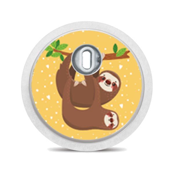 Runder Aufkleber mit Faultieren an einem Ast hängend. Weißer Rand, Loch in der Mitte. Hintergrund: gelb.