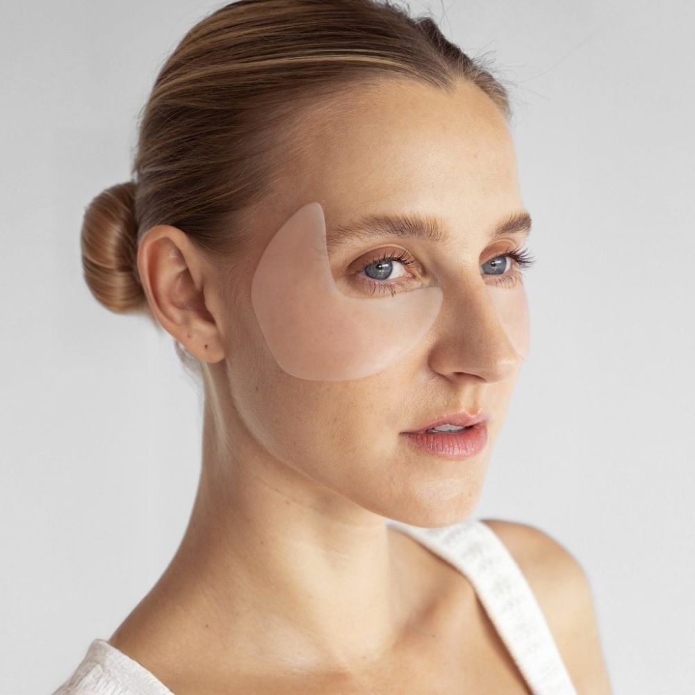 Gesicht einer Frau mit einem Augen-Schläfen Pad. Das Pad bedeckt die Augenpartie und die Schläfe.