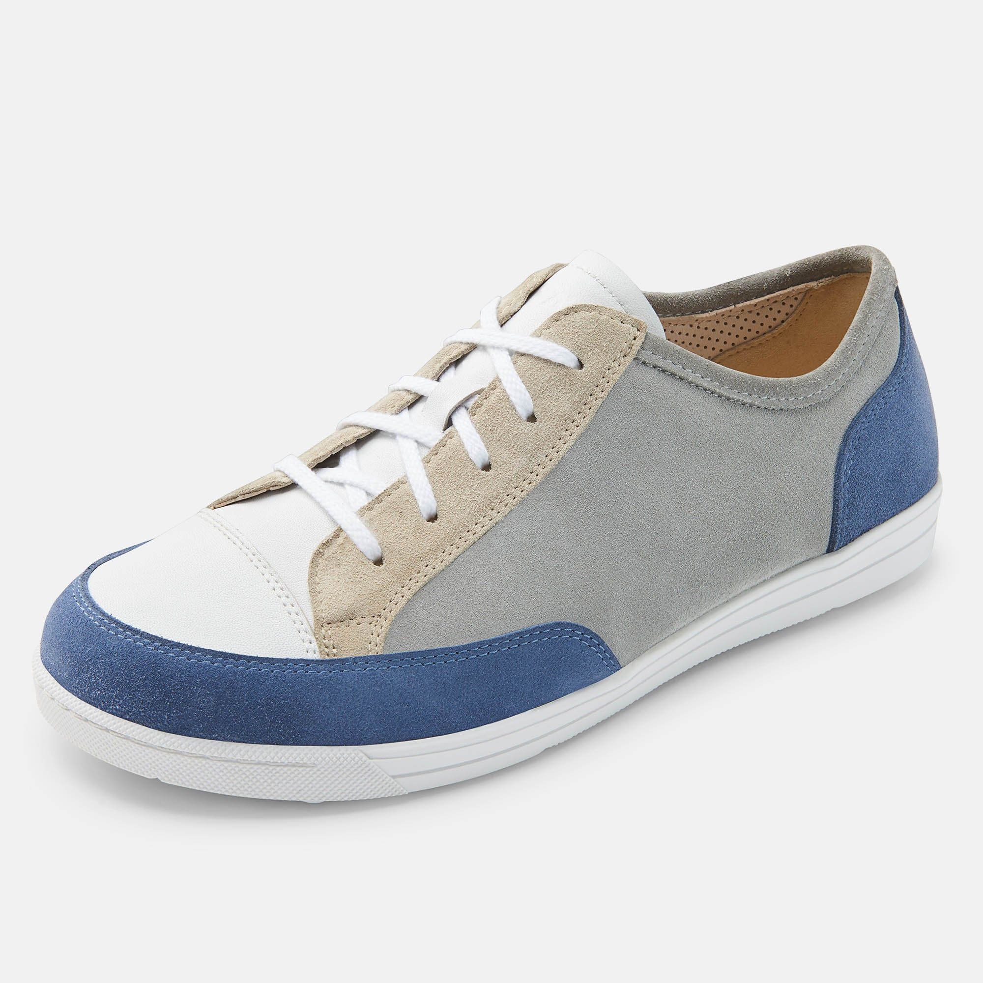 Ein grauer, blauer und weißer Schnürschuh. Der Schuh hat eine breite Passform und ist aus verschiedenen Materialien gefertigt.
