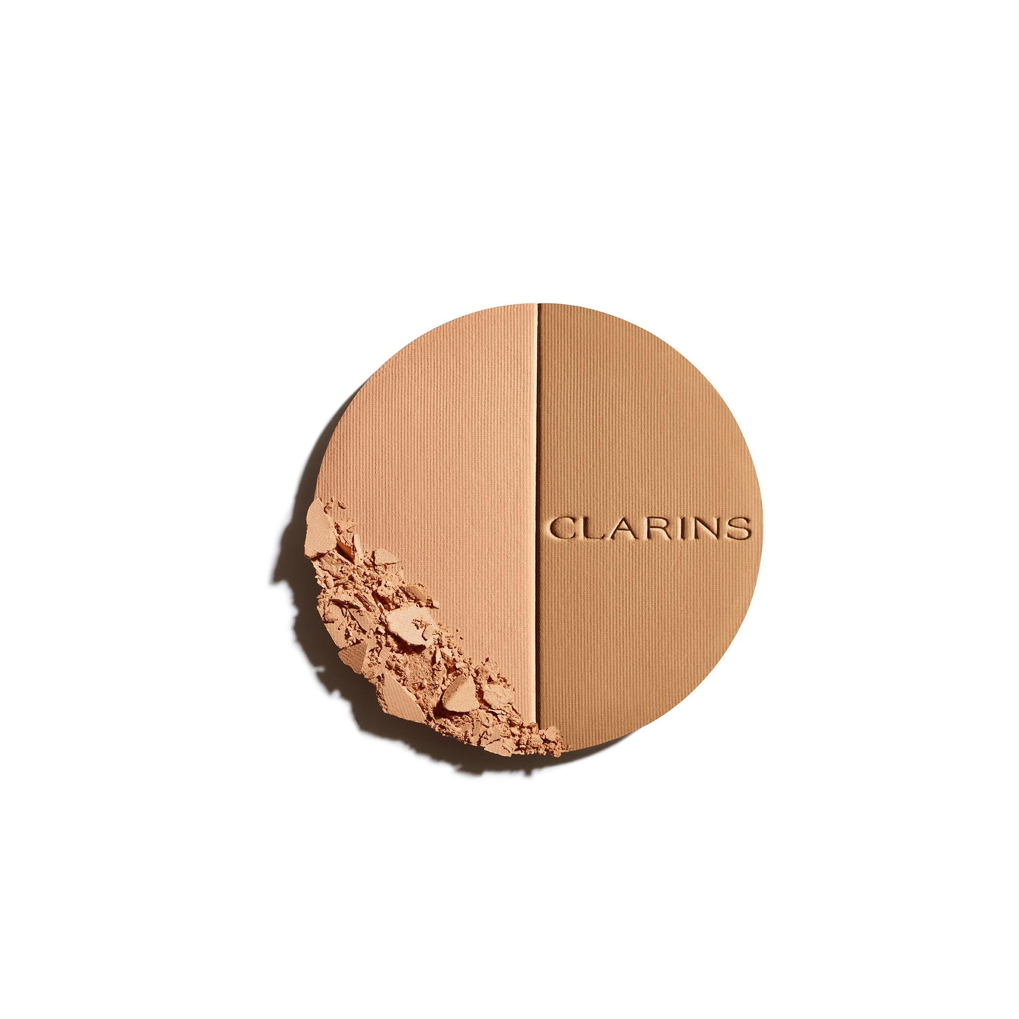 Runder Bronzer-Kompaktpuder mit zwei Farbtönen. Puder mit Clarins-Logo. Einige Puderpartikel sind abgebrochen.