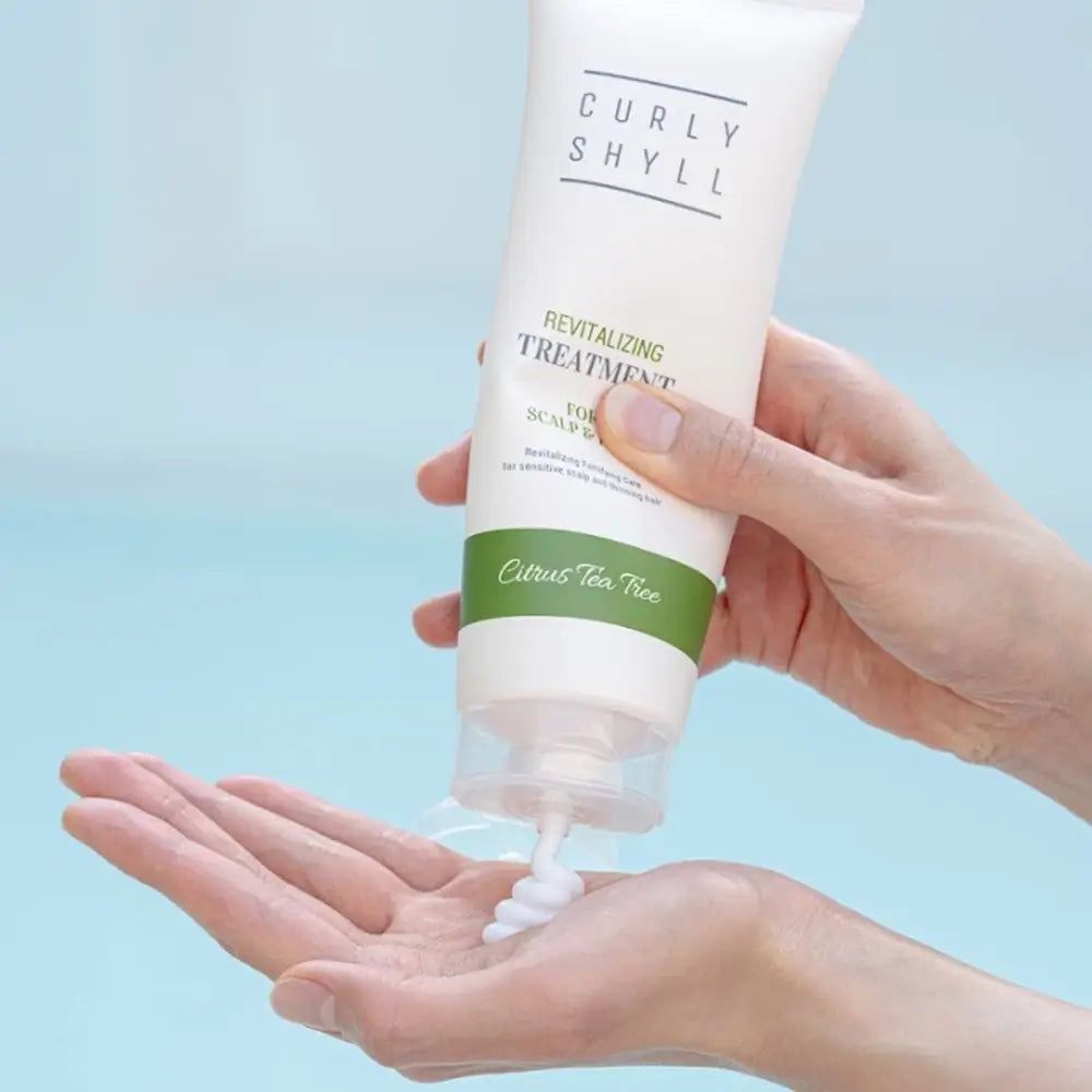 Hände halten eine Tube. Produkt wird herausgedrückt. Text: CURLY SHYLL, Revitalizing Treatment for Scalp & Hair.