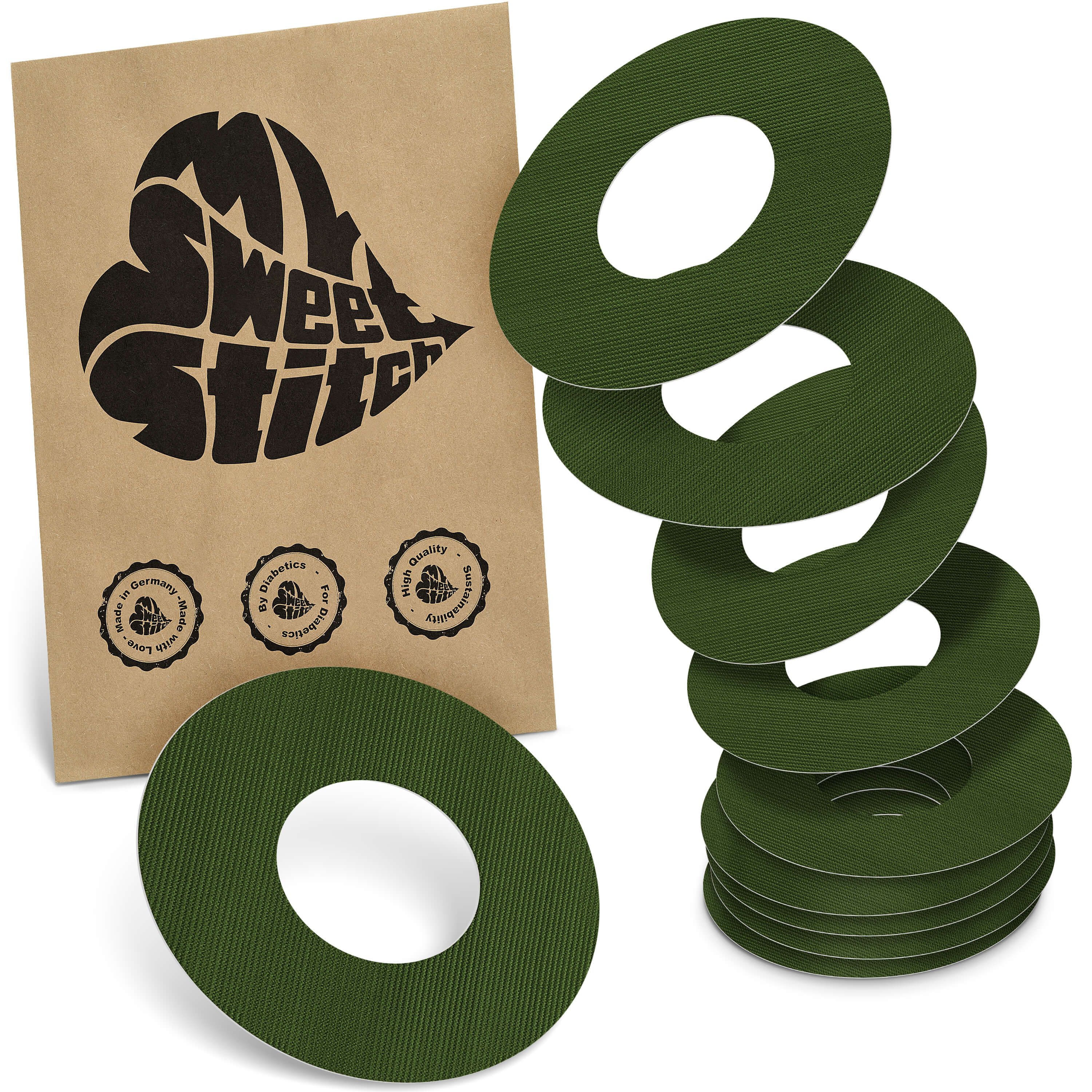 Grüne, ringförmige Pflaster mit Loch in der Mitte. Auf brauner Verpackung steht "My Sweet Stitch". Mehrere Pflaster sind gestapelt.