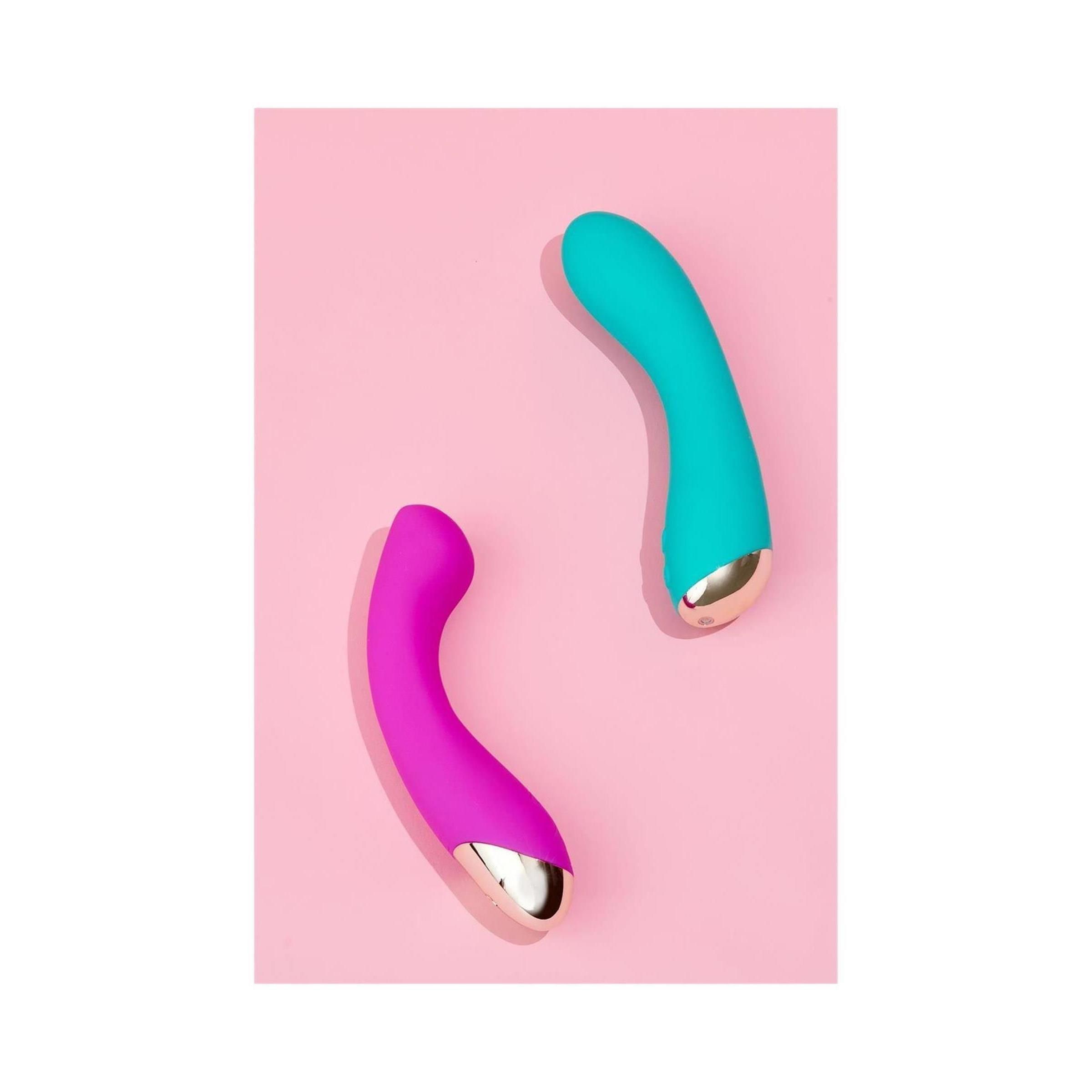 Zwei Wellness-Produkte auf rosa Hintergrund. Türkis und pink, mit goldfarbenen Akzenten. Geschwungene Form.
