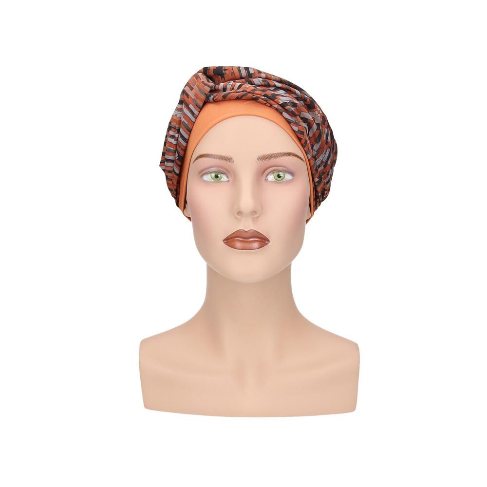 Turban mit orangefarbenem Unterteil und gemustertem Oberteil. Auf einer Schaufensterpuppe, Frontansicht.